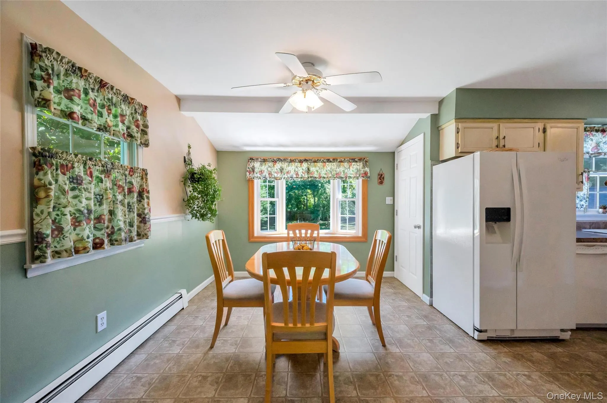Spacious dining area featuring resilient flooring, a ceiling fan, and multiple windows Spacious dining area featuring resilient flooring, a ceiling fan, and multiple windows