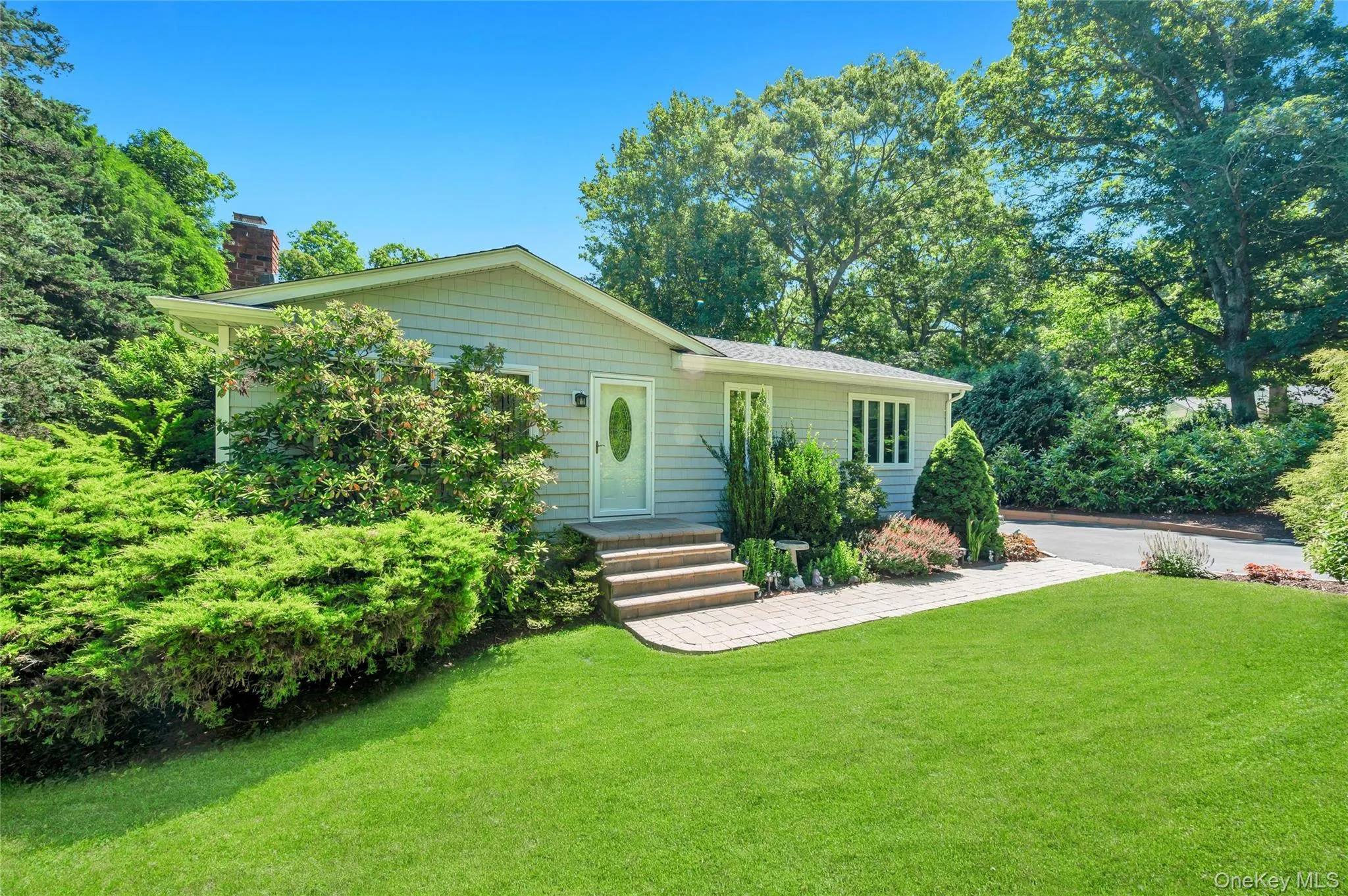 Light-colored siding exterior with a prominent front entrance featuring a white door with an oval glass insert Light-colored siding exterior with a prominent front entrance featuring a white door with an oval glass insert
