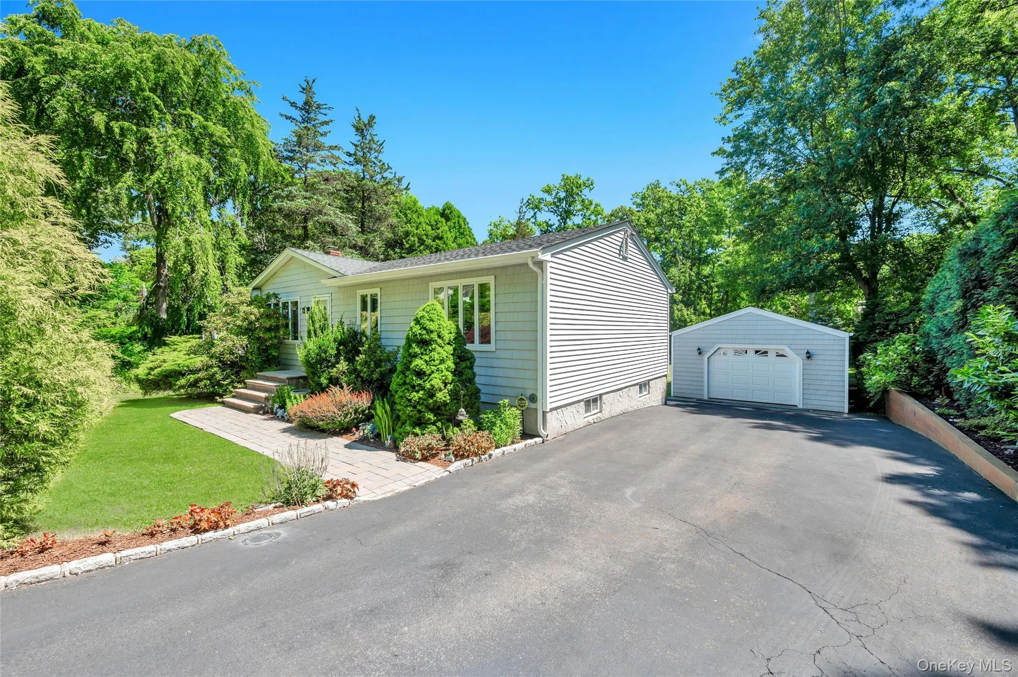 Ranch-style exterior with light gray siding, white trim windows, and an asphalt driveway Ranch-style exterior with light gray siding, white trim windows, and an asphalt driveway
