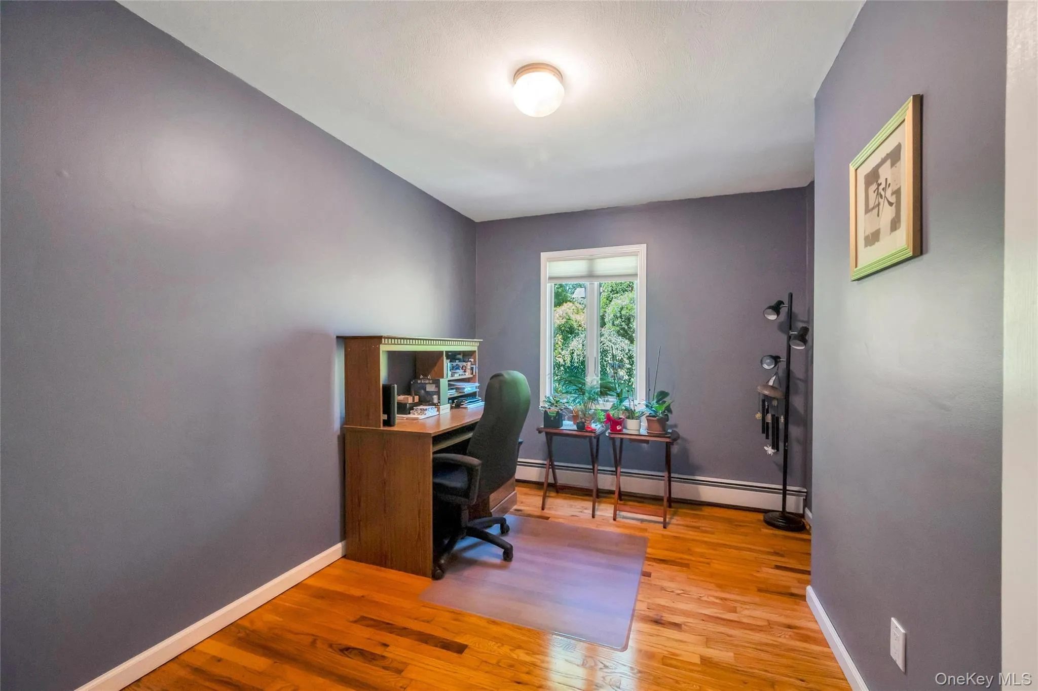 Room featuring wood-finish flooring and a neutral wall color Room featuring wood-finish flooring and a neutral wall color