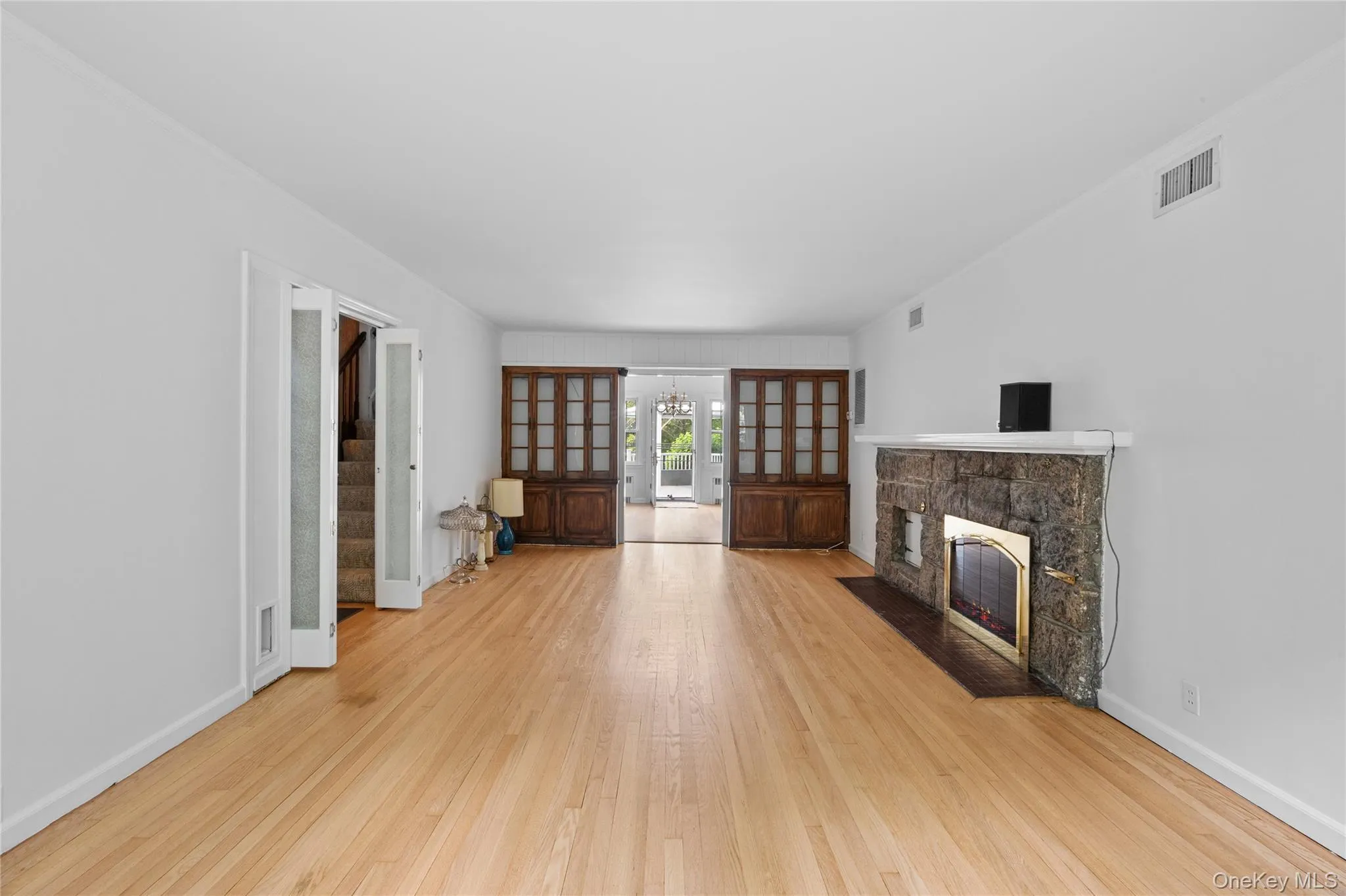 Living Room featuring light wood-finish flooring, a stone-faced fireplace with Brick Living Room featuring light wood-finish flooring, a stone-faced fireplace with Brick