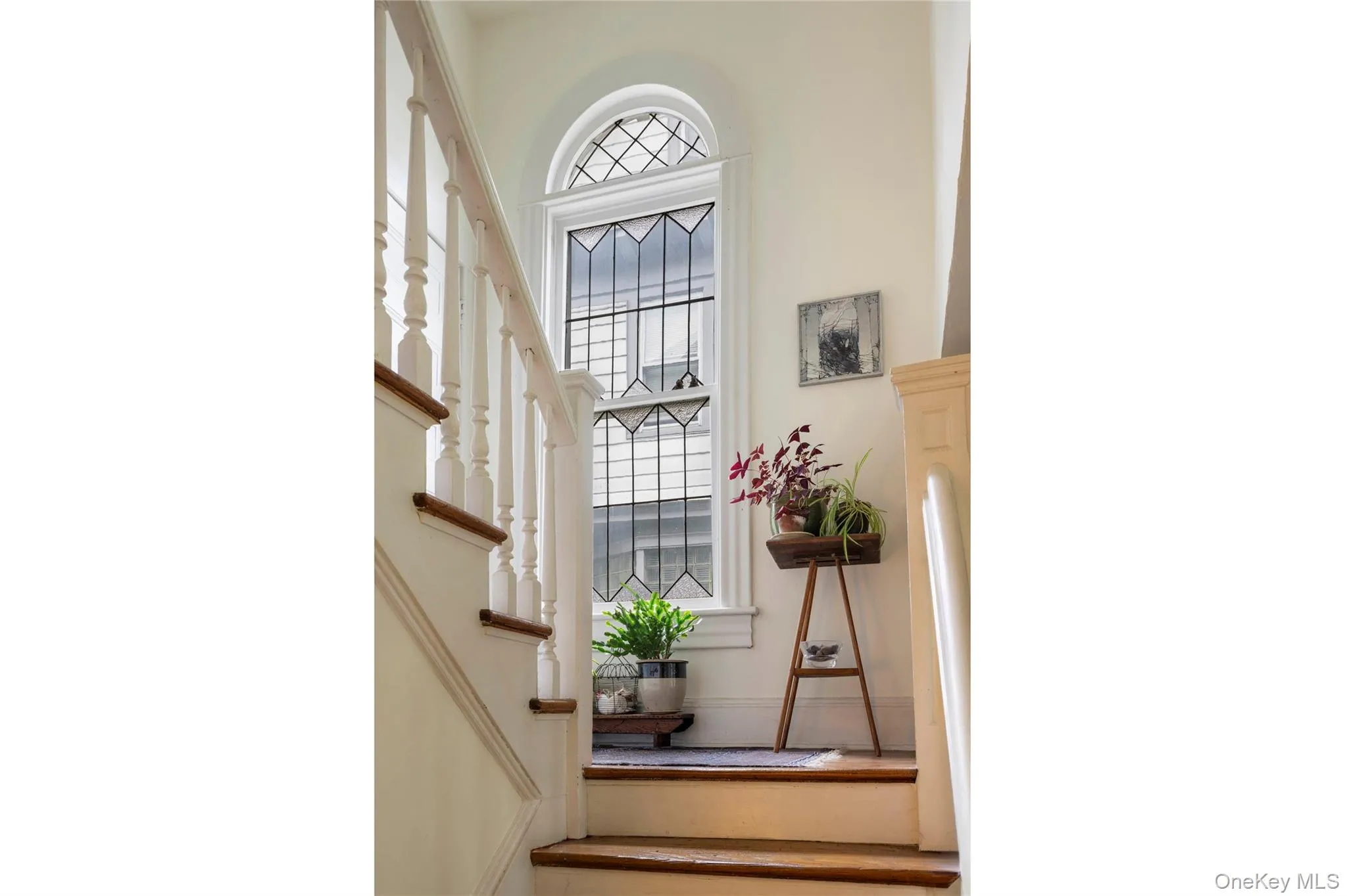 Staircase featuring wood treads, white risers, and a classic white balustrade Staircase featuring wood treads, white risers, and a classic white balustrade