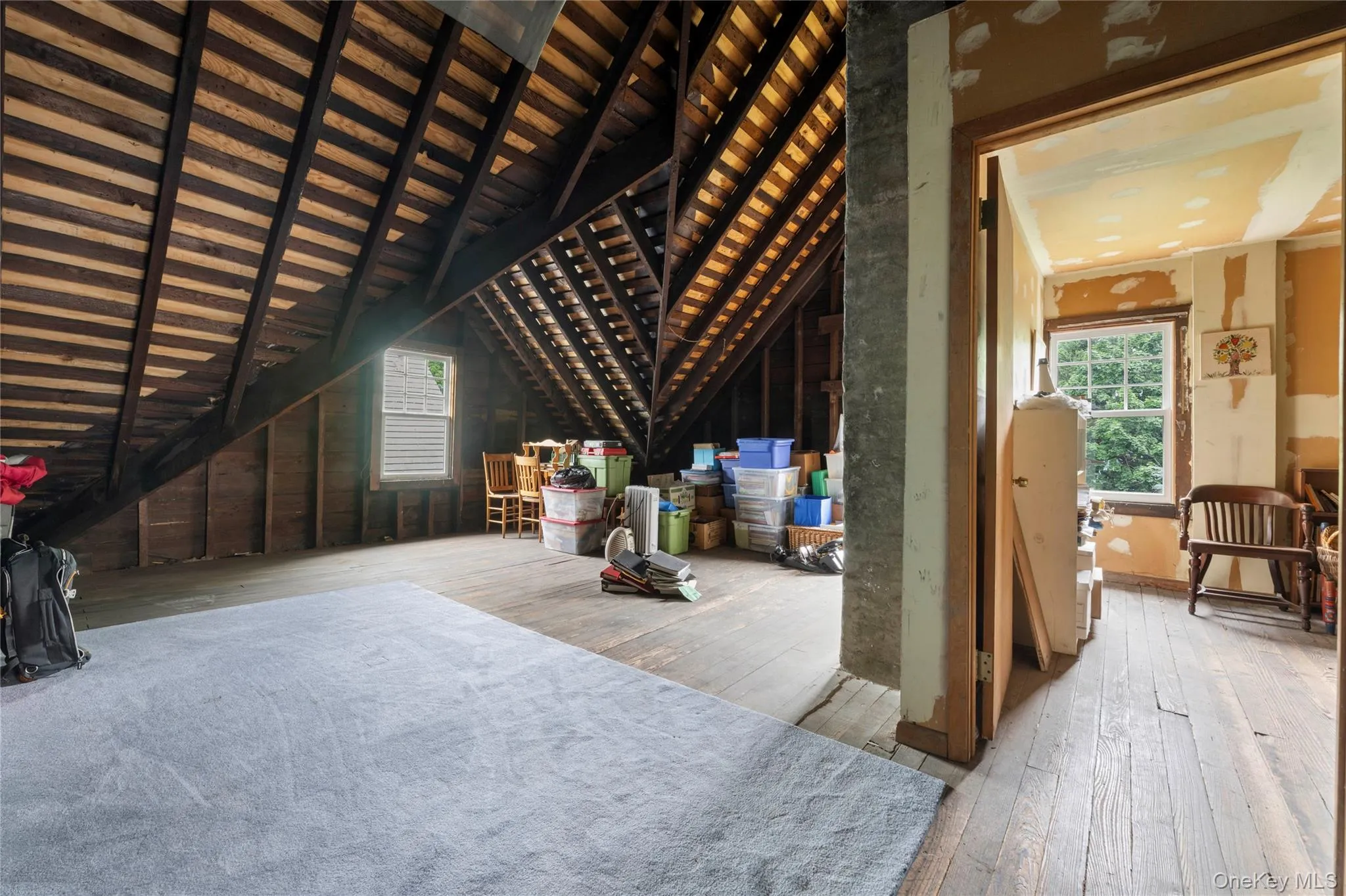 Exposed wood beam ceiling, wood-finish flooring, interior doorway, and window with natural light Exposed wood beam ceiling, wood-finish flooring, interior doorway, and window with natural light