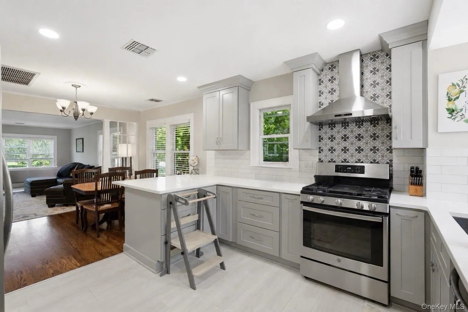 Modern kitchen featuring light gray cabinetry, white countertops, and a subway tile backsplash Modern kitchen featuring light gray cabinetry, white countertops, and a subway tile backsplash