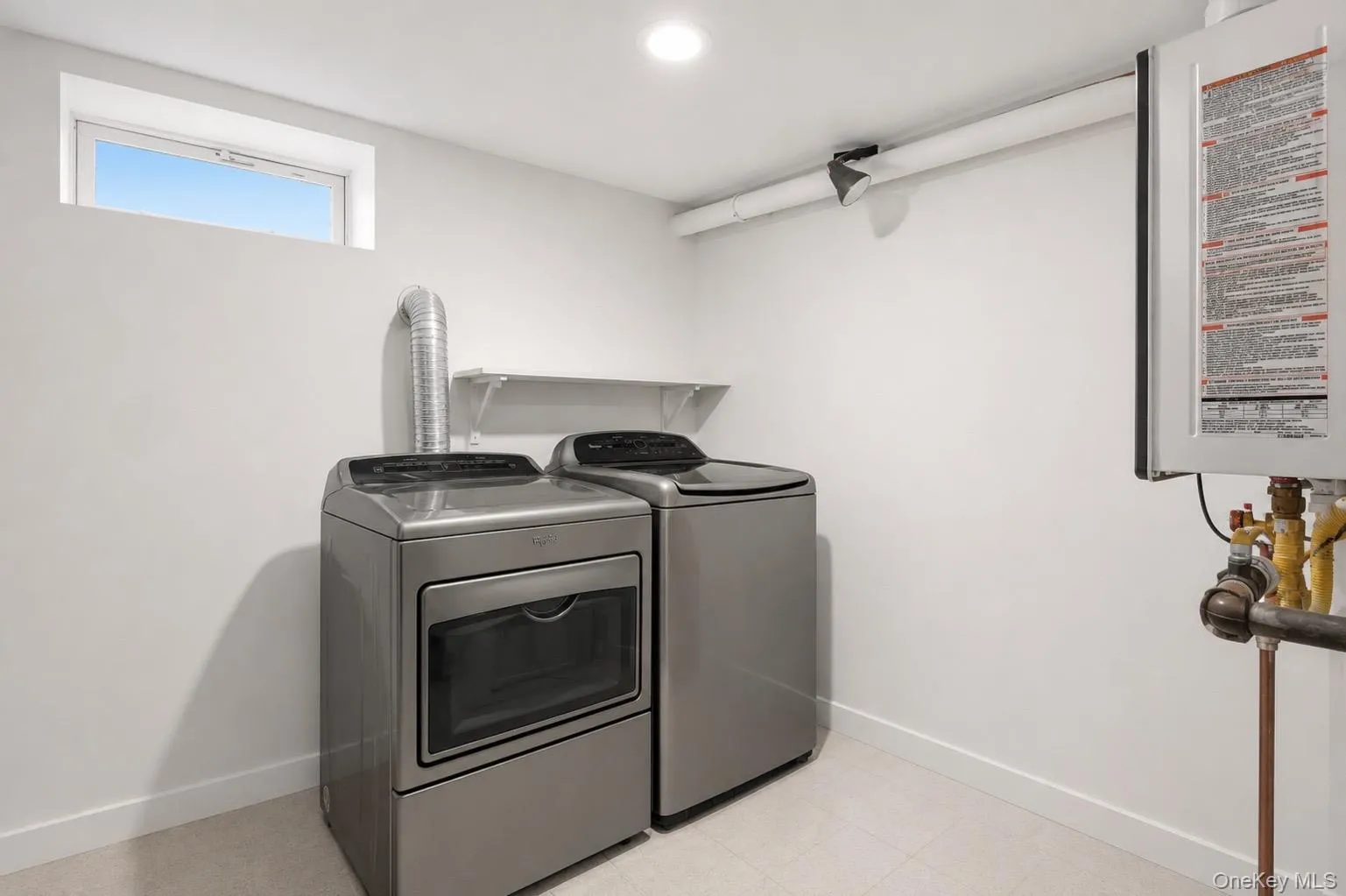Dedicated laundry space featuring a white utility shelf, recessed lighting, and a high window Dedicated laundry space featuring a white utility shelf, recessed lighting, and a high window