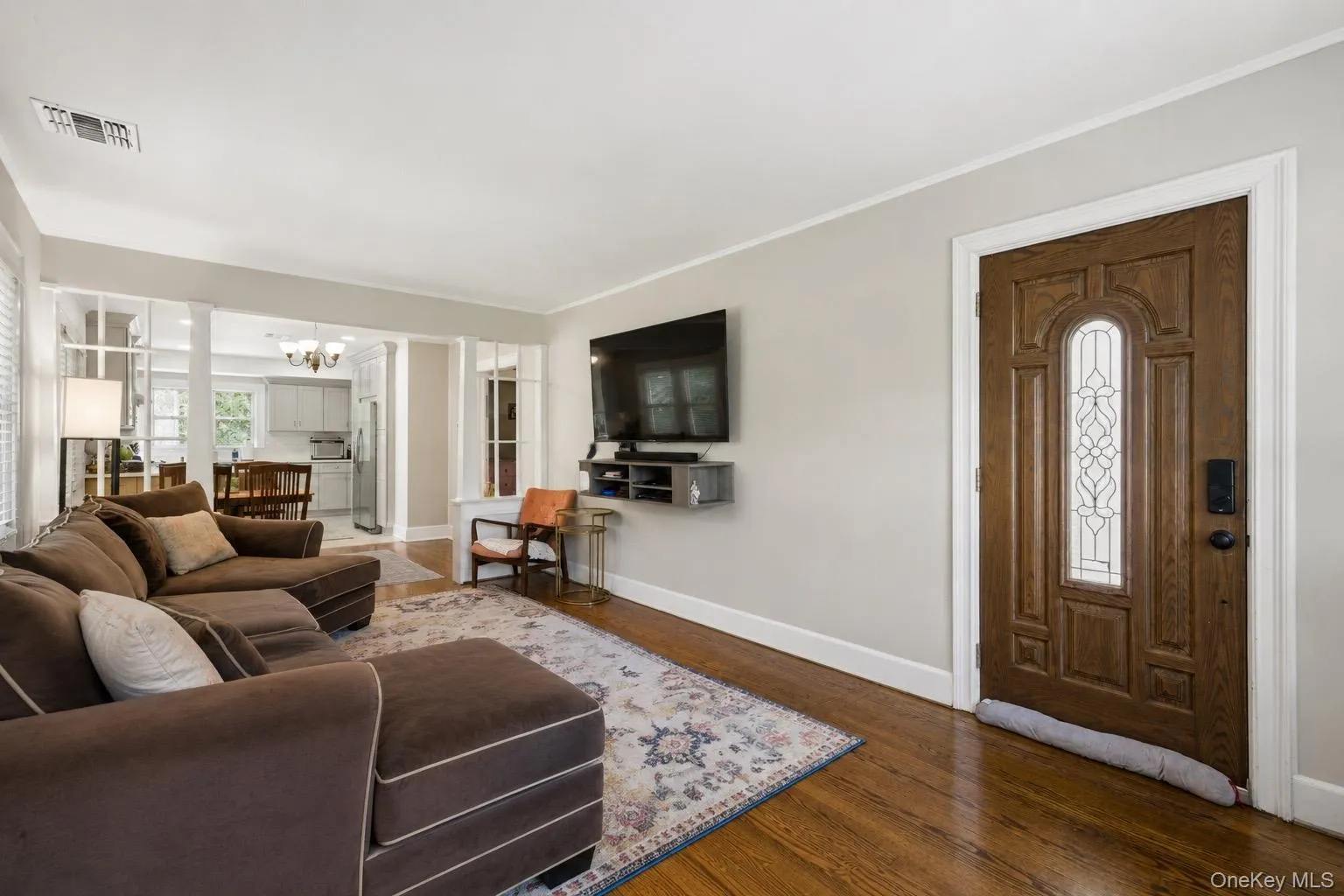 Rich wood-finish flooring complements the detailed wood entry door Rich wood-finish flooring complements the detailed wood entry door