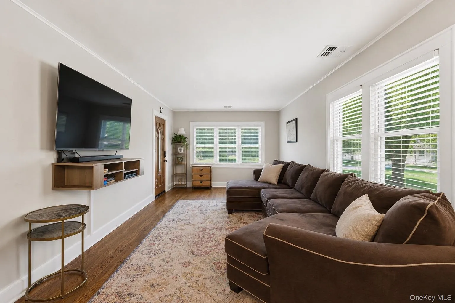 Living area featuring wood-finish flooring, white trim, and light gray wall paint Living area featuring wood-finish flooring, white trim, and light gray wall paint