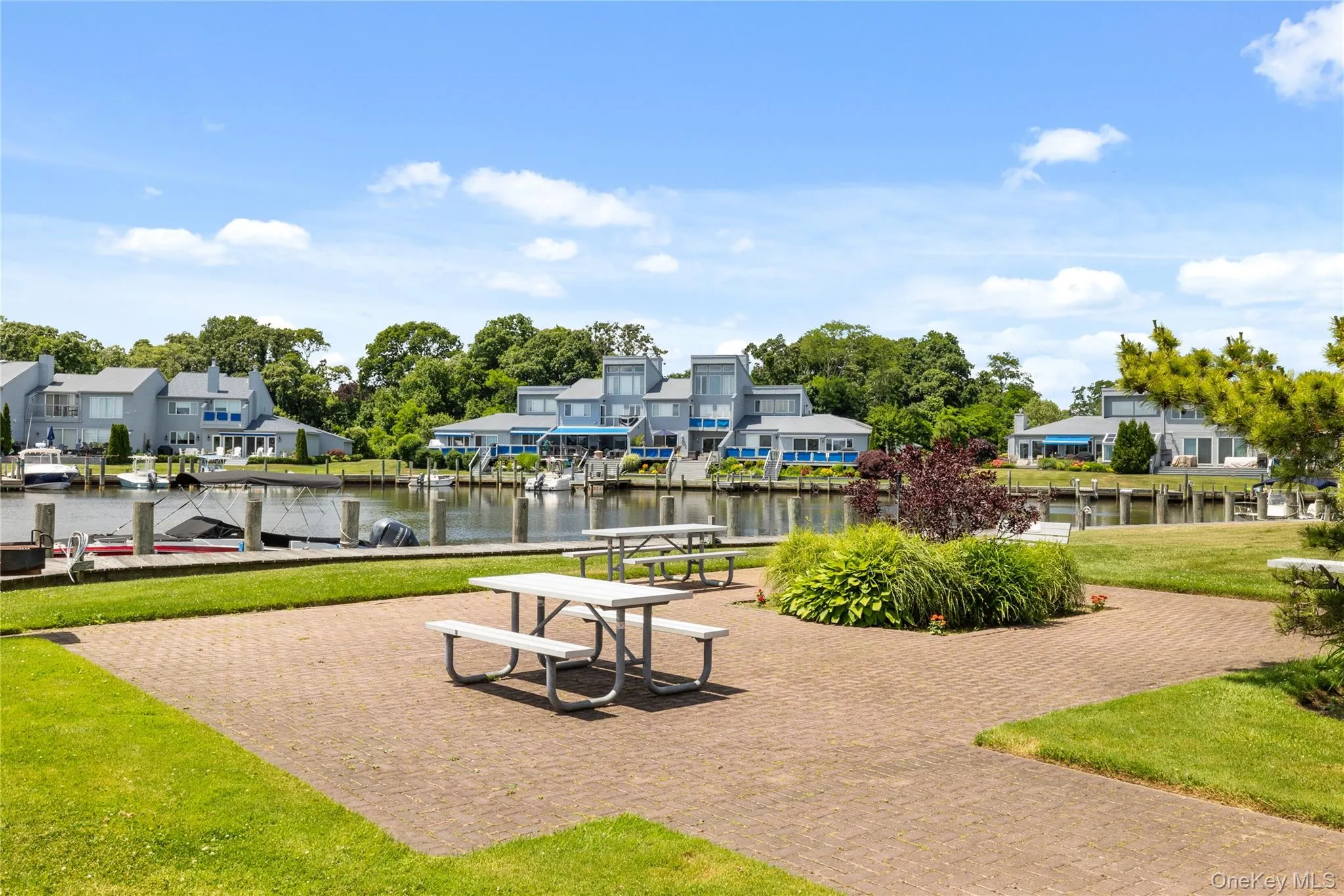 View of community bbq area with a residential view, a dock, and a water view View of community bbq area with a residential view, a dock, and a water view