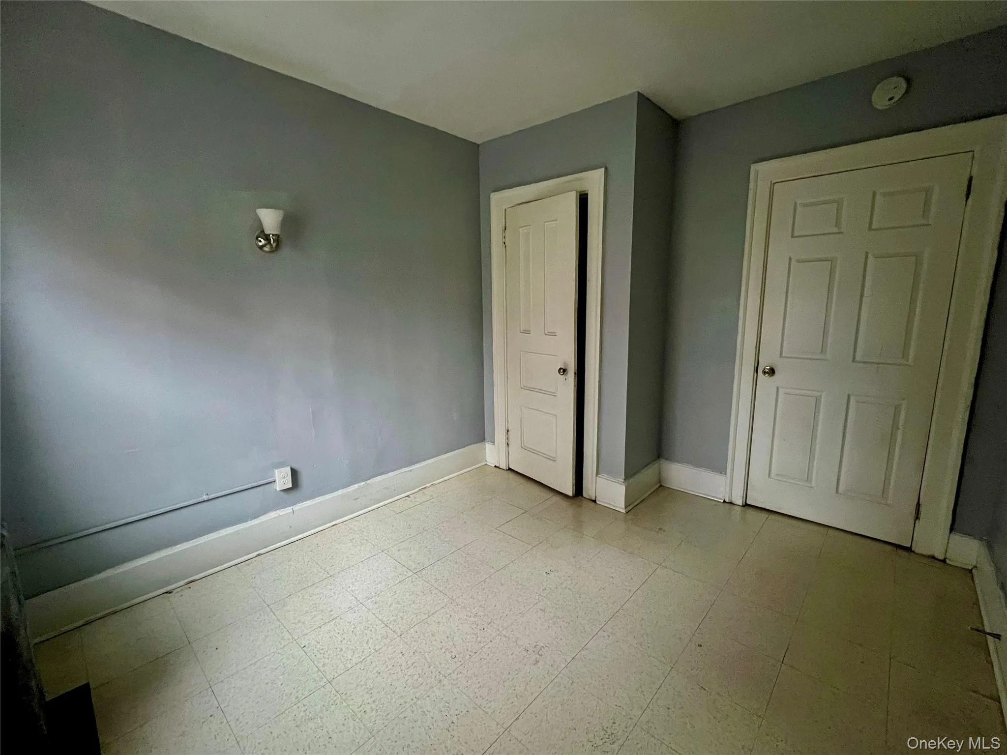 Unfurnished bedroom with light flooring and baseboards Unfurnished bedroom with light flooring and baseboards