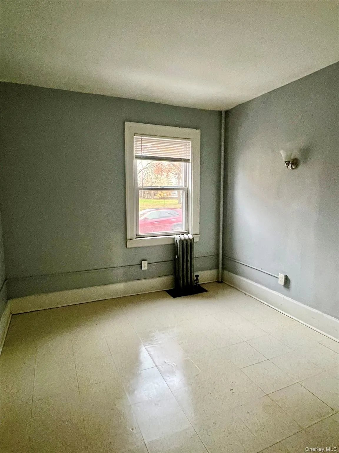 Spare room featuring tile patterned floors and radiator Spare room featuring tile patterned floors and radiator