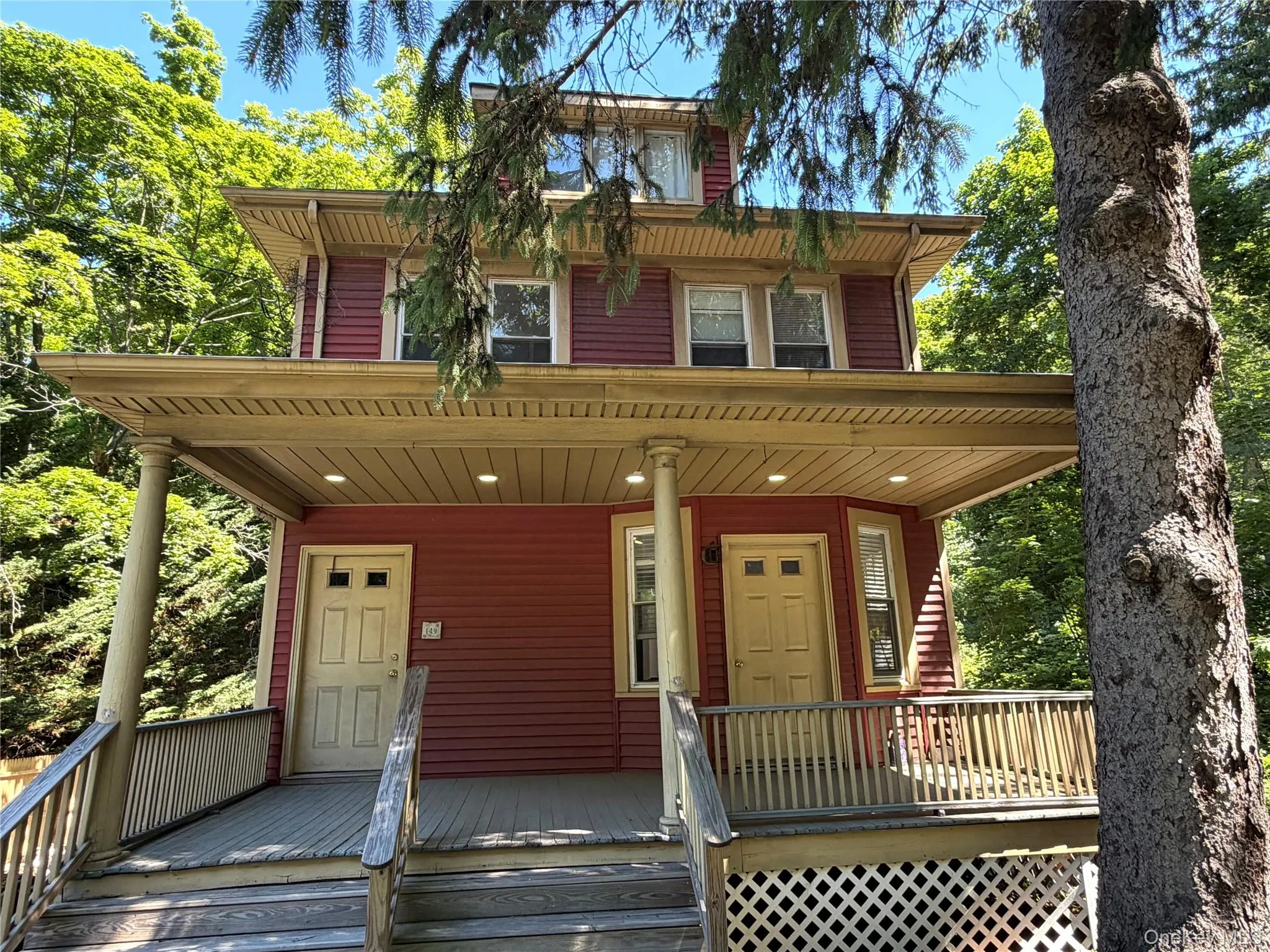 Three story property featuring a prominent covered porch with decorative columns Three story property featuring a prominent covered porch with decorative columns