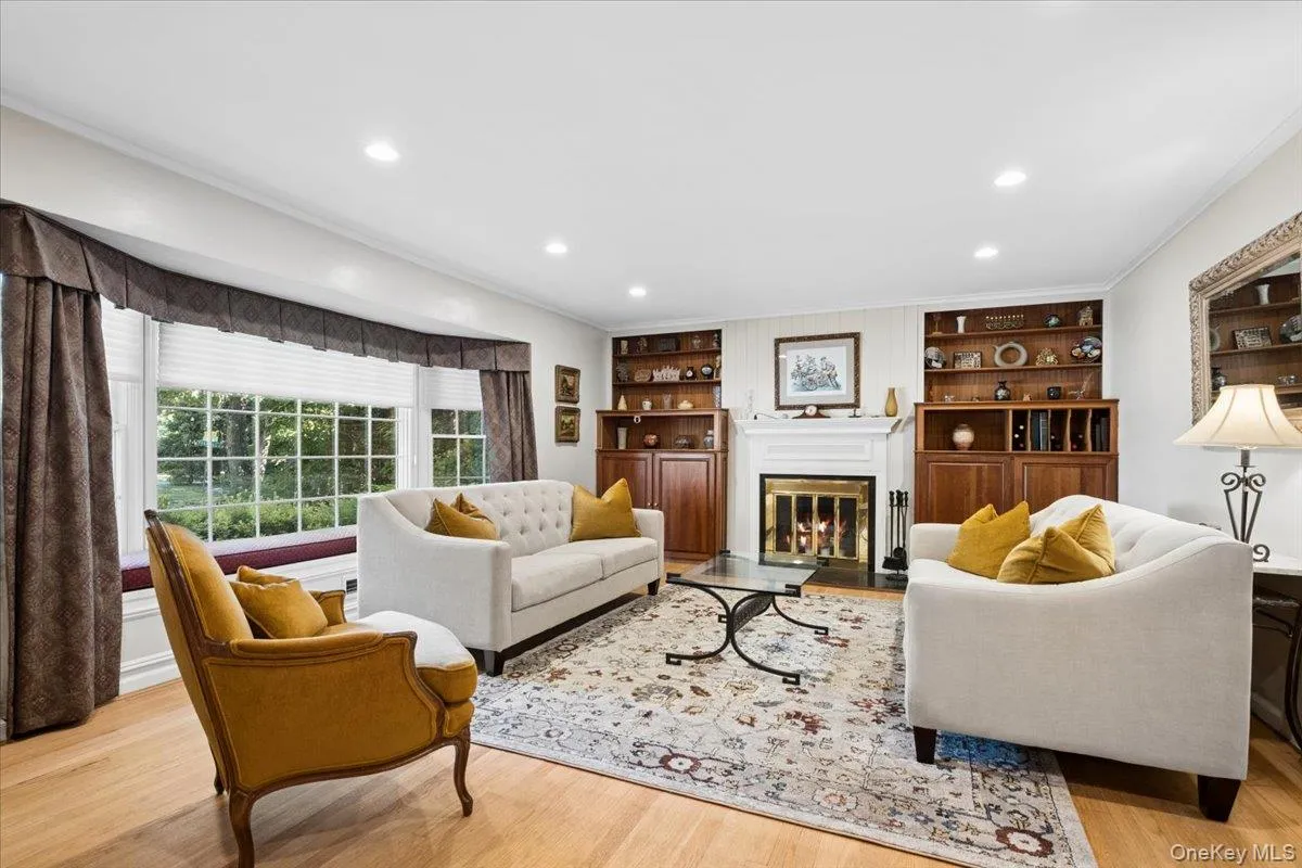 Living room featuring fireplace, built-ins and bay window with window seat Living room featuring fireplace, built-ins and bay window with window seat