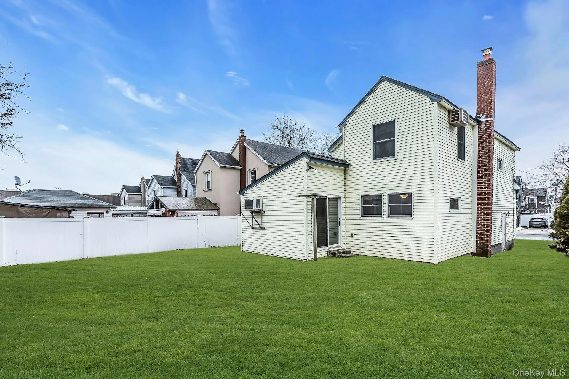 Expansive green lawn with a white privacy fence Expansive green lawn with a white privacy fence