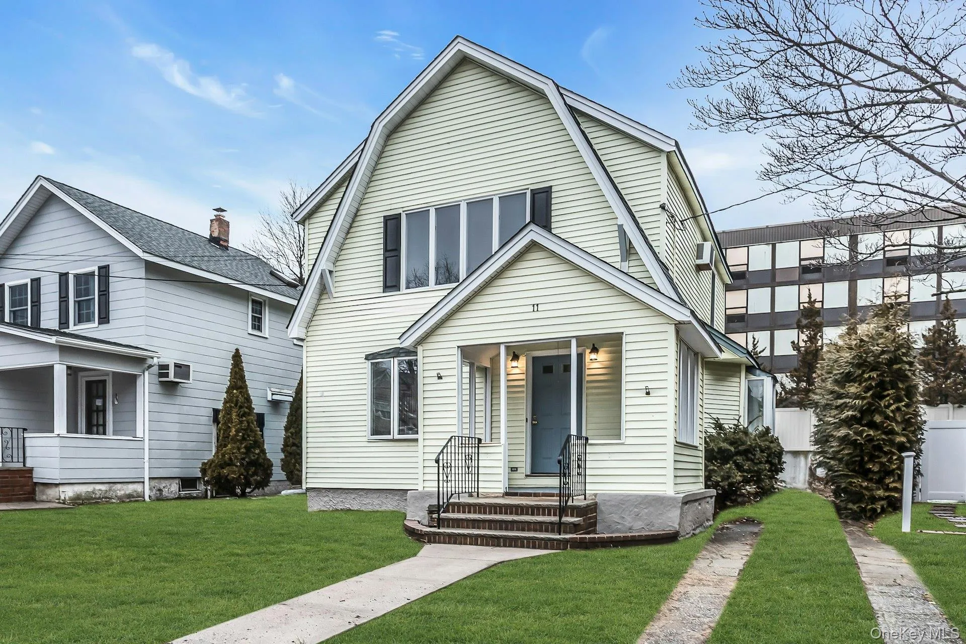 Gable-front home featuring light-colored siding and a blue entry door Gable-front home featuring light-colored siding and a blue entry door