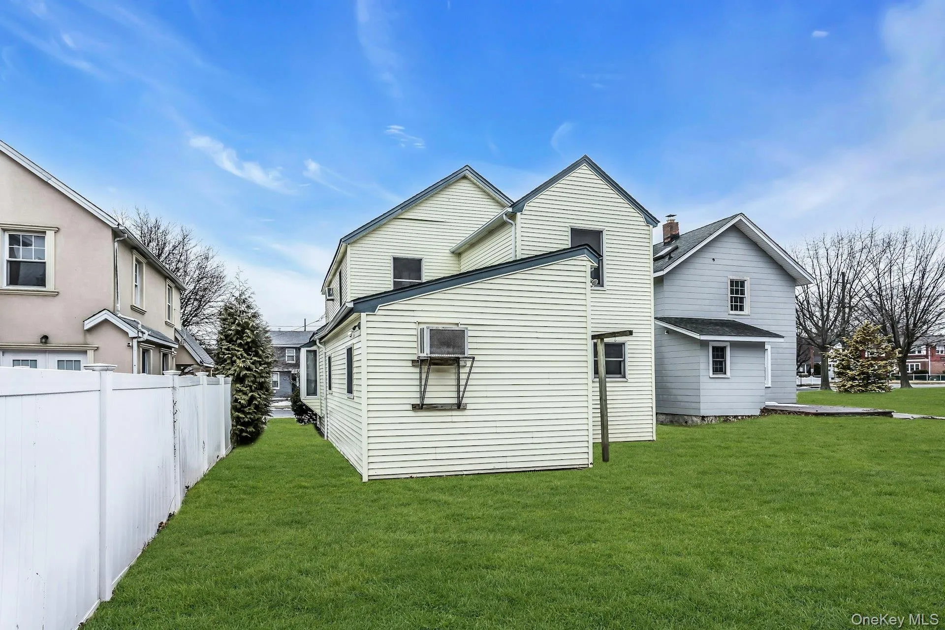 Expansive grassy yard with a white privacy fence Expansive grassy yard with a white privacy fence