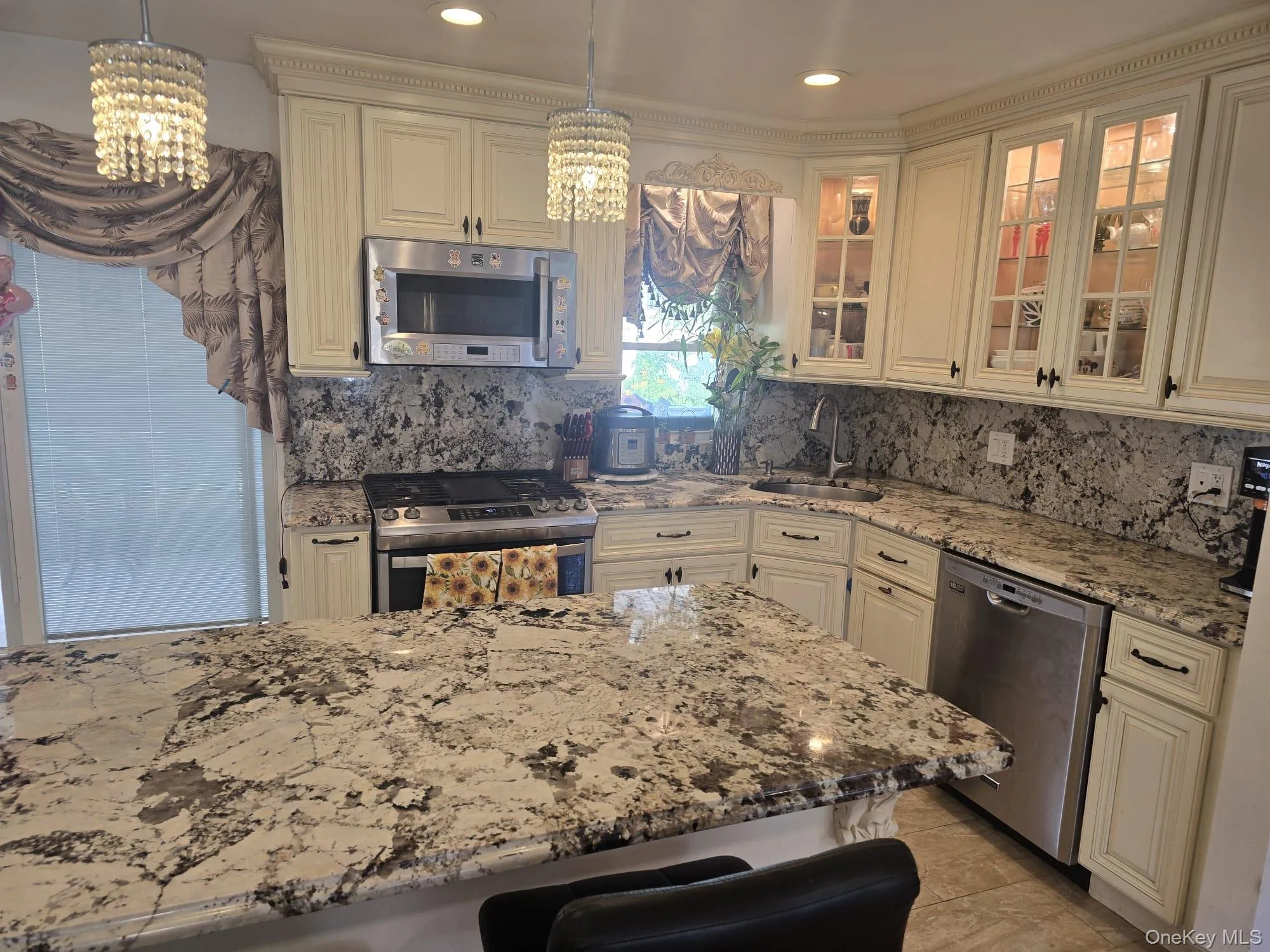 Kitchen featuring cream-colored cabinetry with decorative molding Kitchen featuring cream-colored cabinetry with decorative molding