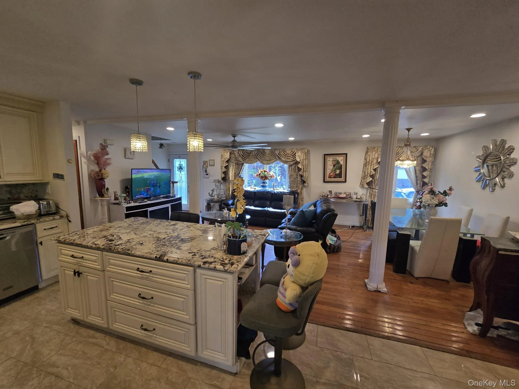 Kitchen island featuring a patterned countertop with pendant lighting, integrated cabinetry, and tiled flooring Kitchen island featuring a patterned countertop with pendant lighting, integrated cabinetry, and tiled flooring