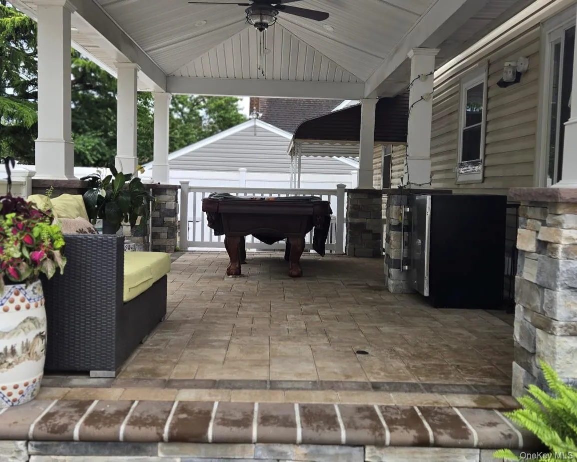 Covered patio featuring a ceiling fan, recessed lighting, and a stone-clad outdoor kitchen area Covered patio featuring a ceiling fan, recessed lighting, and a stone-clad outdoor kitchen area