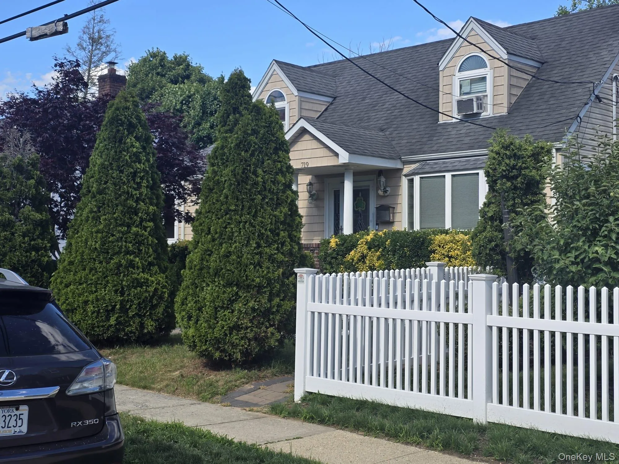 Traditional residence featuring dormer windows, a bay window, and a white picket fence Traditional residence featuring dormer windows, a bay window, and a white picket fence