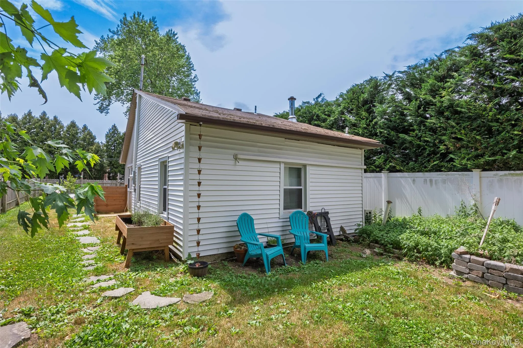 Exterior with white vinyl siding, a brown shingle roof, and a rain chain Exterior with white vinyl siding, a brown shingle roof, and a rain chain