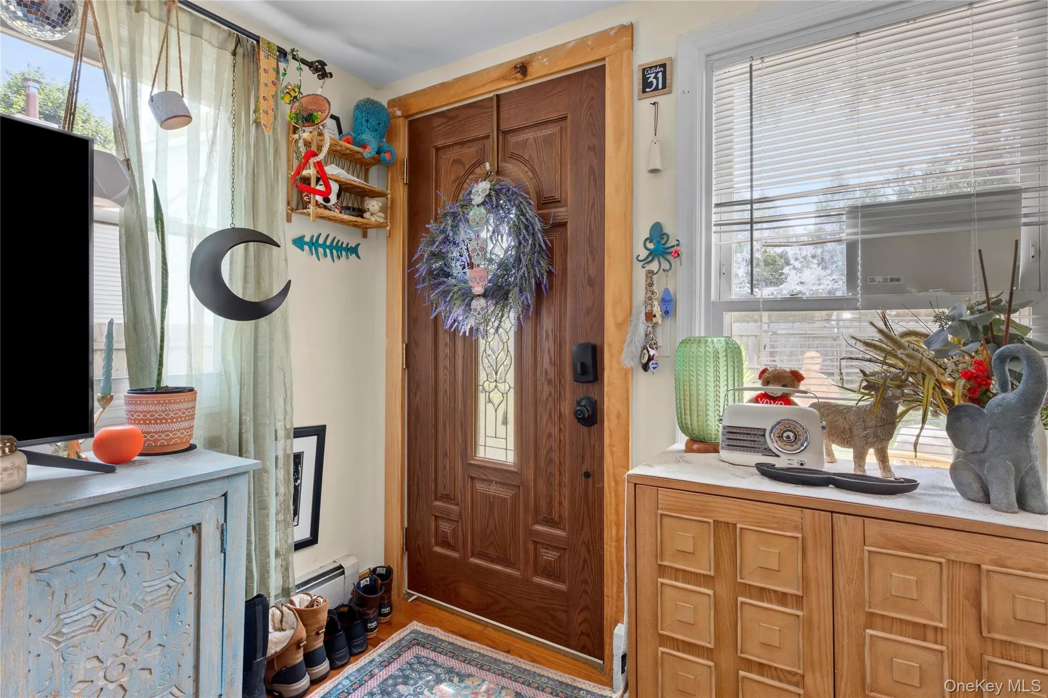 Entryway featuring a wood-panel door with decorative glass inserts, natural wood trim, and light-toned walls Entryway featuring a wood-panel door with decorative glass inserts, natural wood trim, and light-toned walls