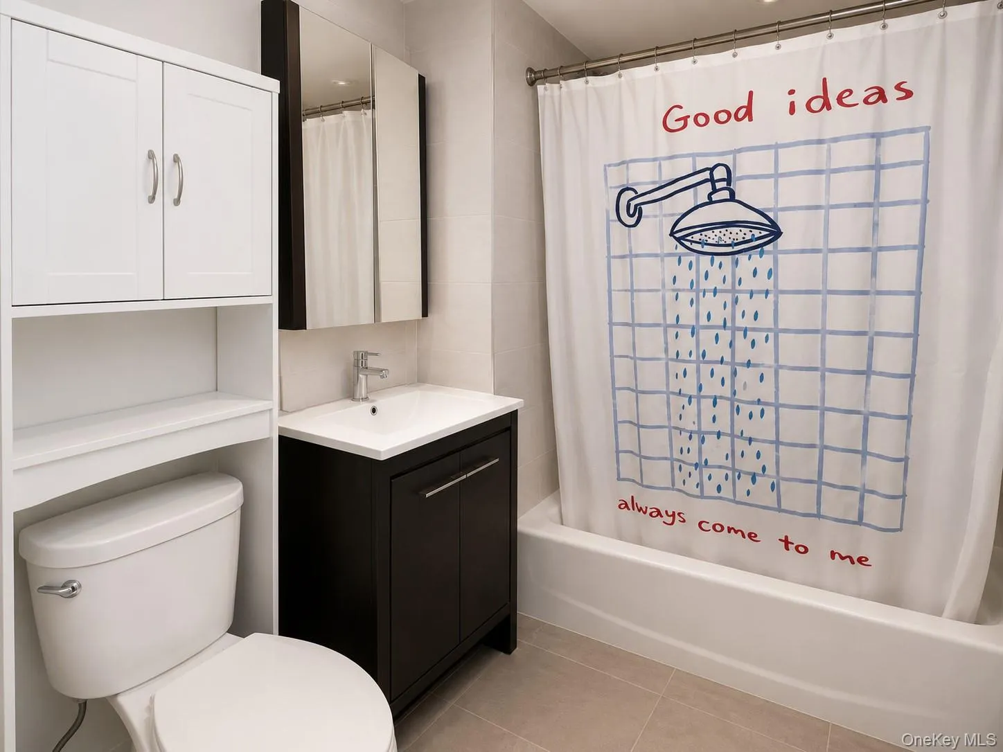 Bathroom featuring a white tub, chrome faucet, dark wood-finish vanity with an integrated sink, and a white medicine cabinet with mirrored doors Bathroom featuring a white tub, chrome faucet, dark wood-finish vanity with an integrated sink, and a white medicine cabinet with mirrored doors