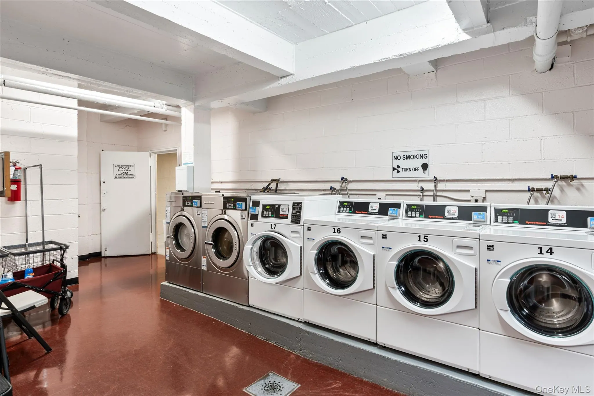 Communal laundry room with independent washer and dryer and concrete block wall Communal laundry room with independent washer and dryer and concrete block wall