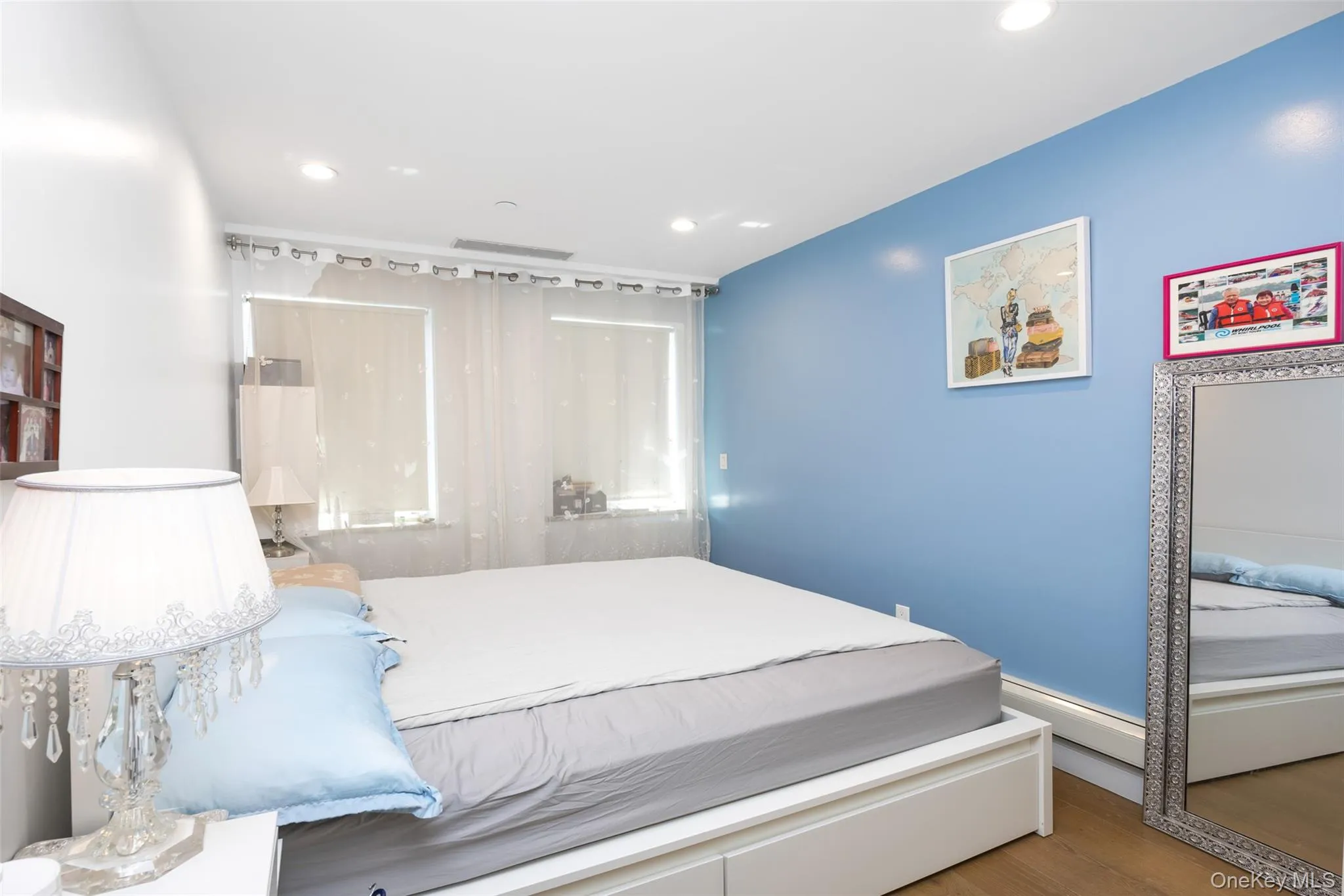 Bedroom featuring wood finished floors, recessed lighting, and baseboard heating Bedroom featuring wood finished floors, recessed lighting, and baseboard heating