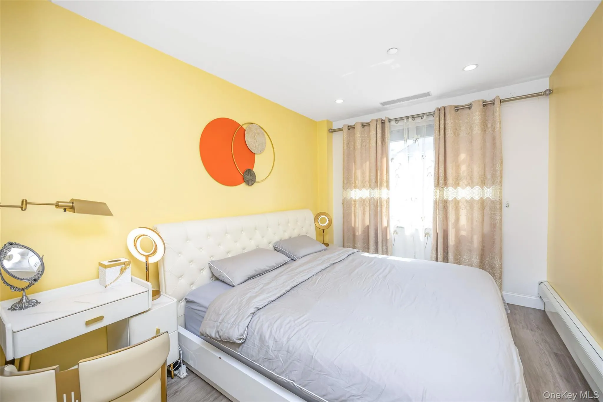 Bedroom featuring a baseboard heating unit, recessed lighting, and wood finished floors Bedroom featuring a baseboard heating unit, recessed lighting, and wood finished floors