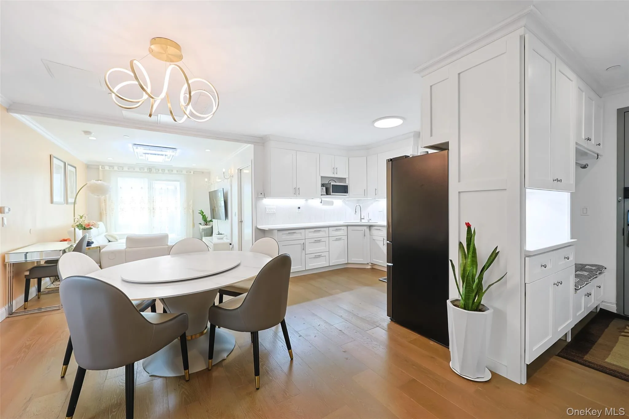 Dining area with light wood-type flooring, crown molding, and a chandelier Dining area with light wood-type flooring, crown molding, and a chandelier