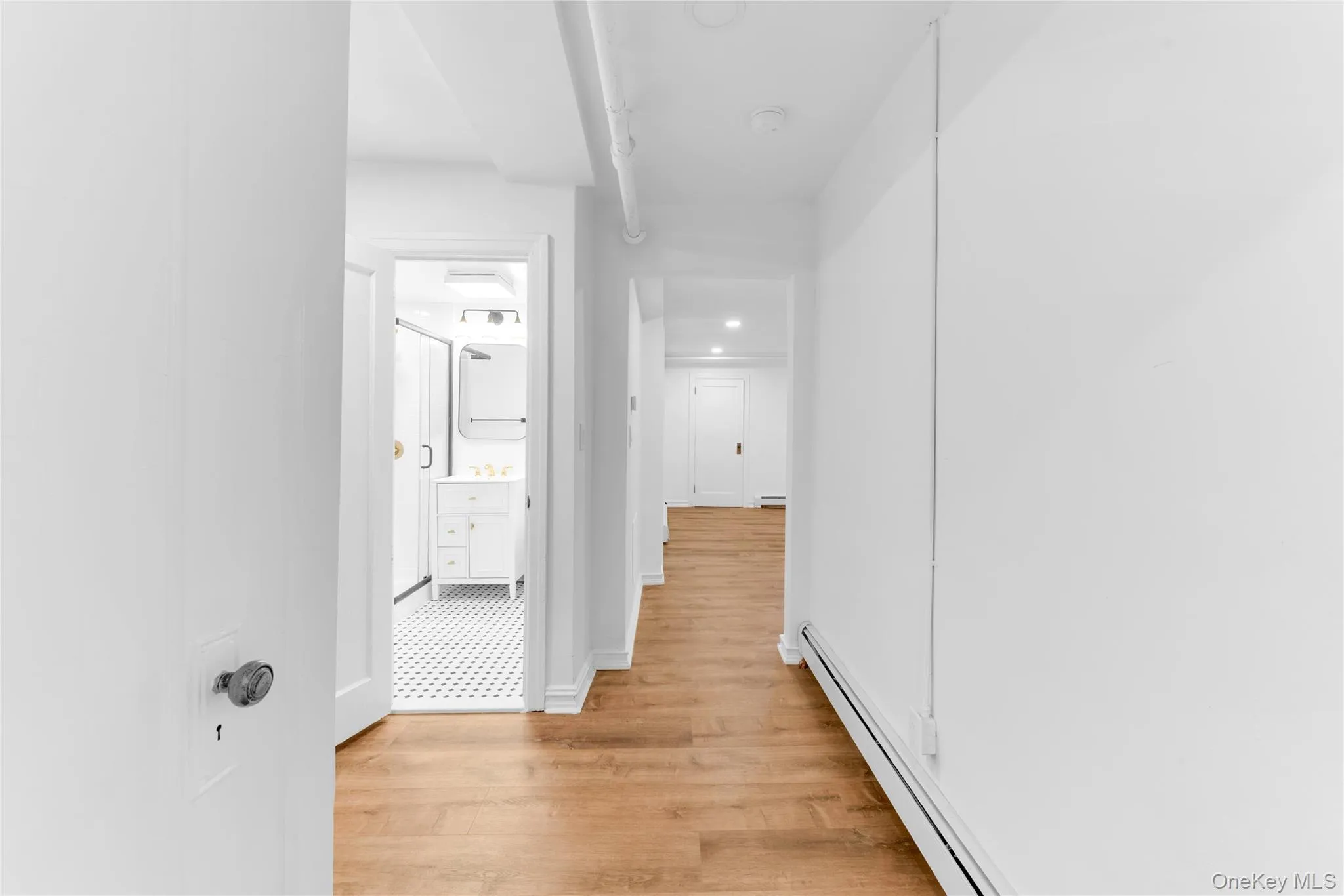 Hallway in lower level with bathroom and living area view Hallway in lower level with bathroom and living area view