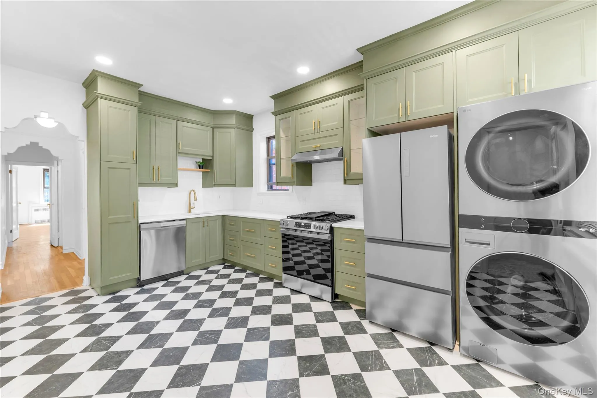 Upper level custom eat-in kitchen with stainless steel appliances and washer / dryer Upper level custom eat-in kitchen with stainless steel appliances and washer / dryer