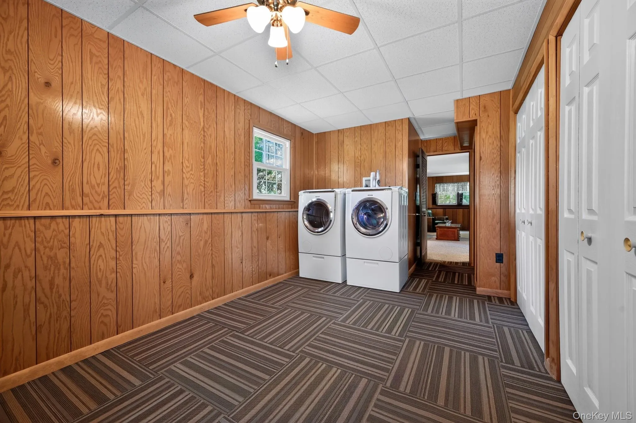Utility room featuring Bosch Front loader washer and dryer on pedestal bases and storage closets. Utility room featuring Bosch Front loader washer and dryer on pedestal bases and storage closets.