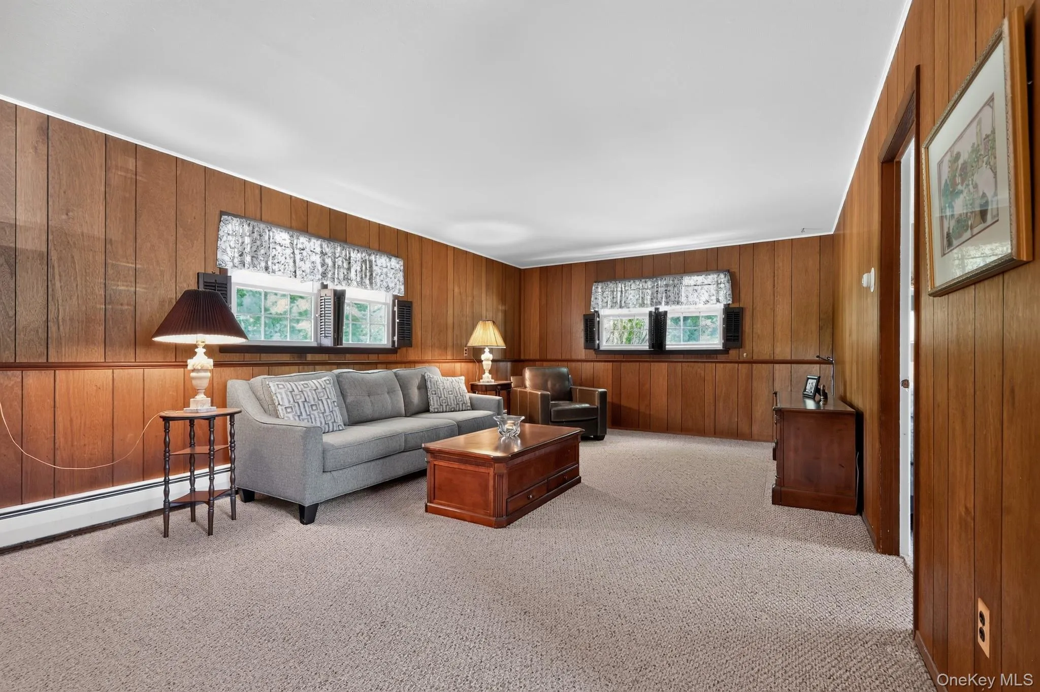 Spacious family room featuring wood paneled walls, berber carpeting and bright white ceiling Spacious family room featuring wood paneled walls, berber carpeting and bright white ceiling