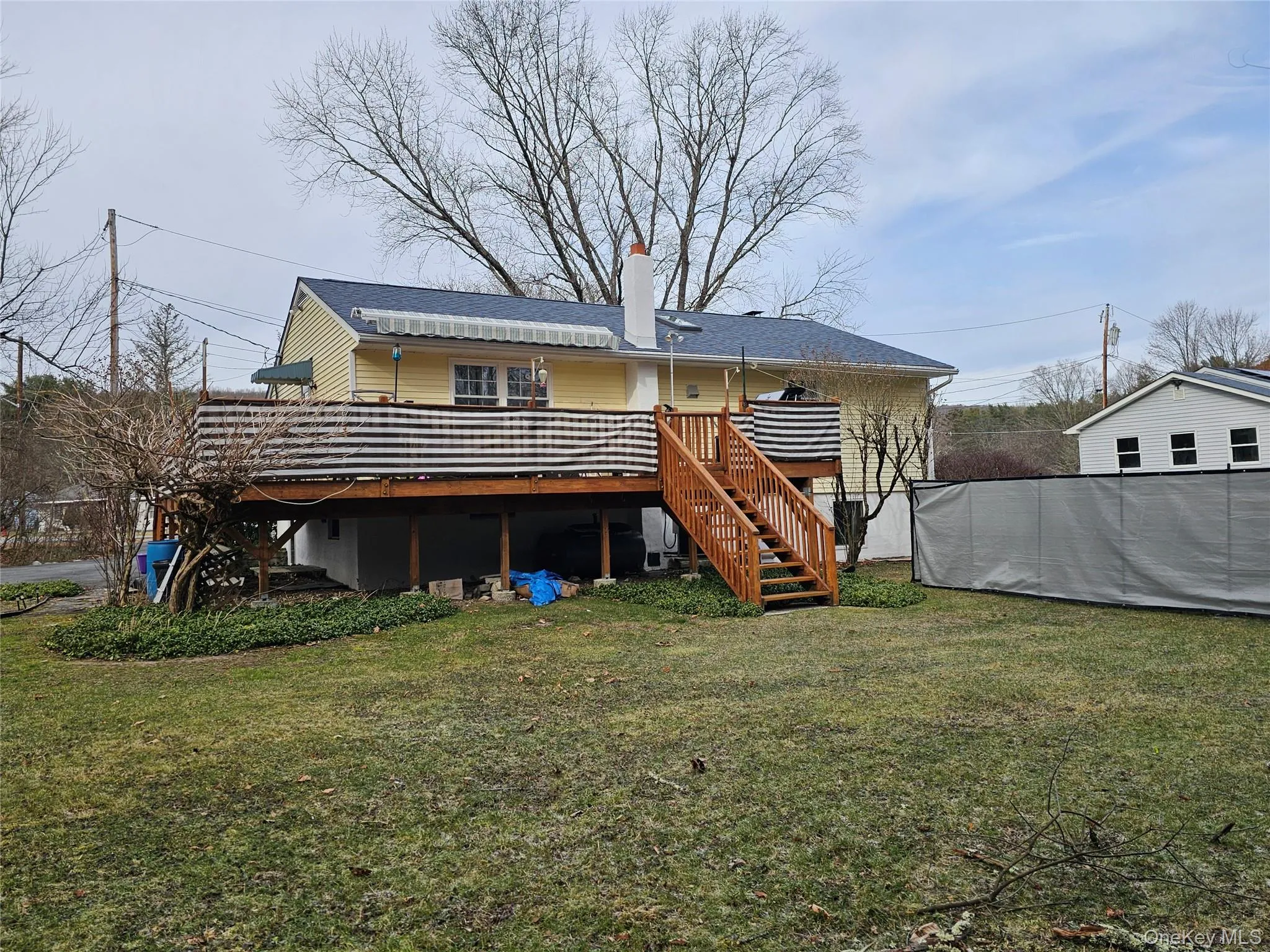 Rear view of house featuring a yard and a wooden deck Rear view of house featuring a yard and a wooden deck