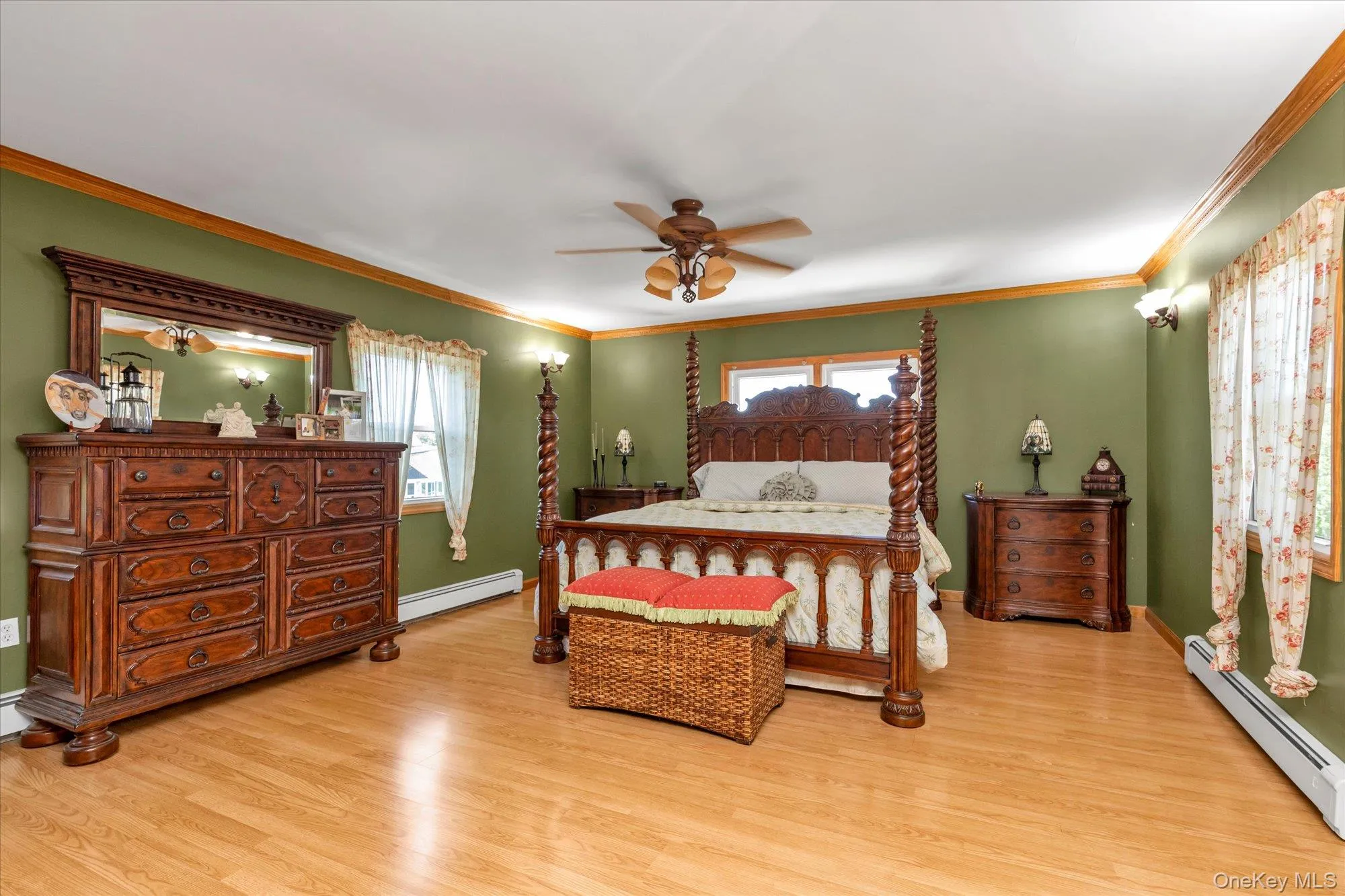Spacious room with wood-finish flooring, two windows, crown molding, and a ceiling fan with integrated lighting Spacious room with wood-finish flooring, two windows, crown molding, and a ceiling fan with integrated lighting