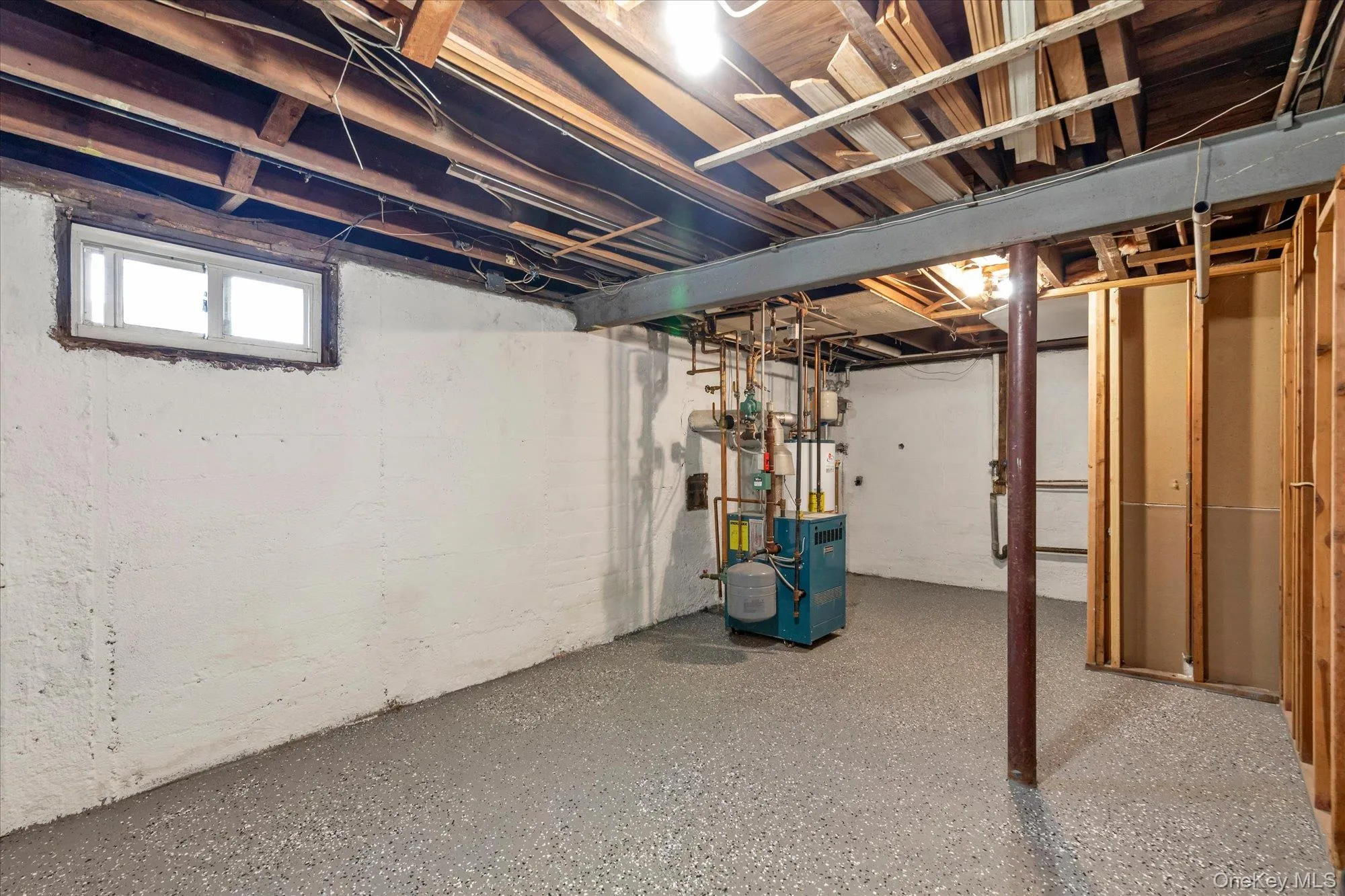 Unfinished basement with a window, exposed ceiling joists, and a utility area featuring mechanical equipment Unfinished basement with a window, exposed ceiling joists, and a utility area featuring mechanical equipment