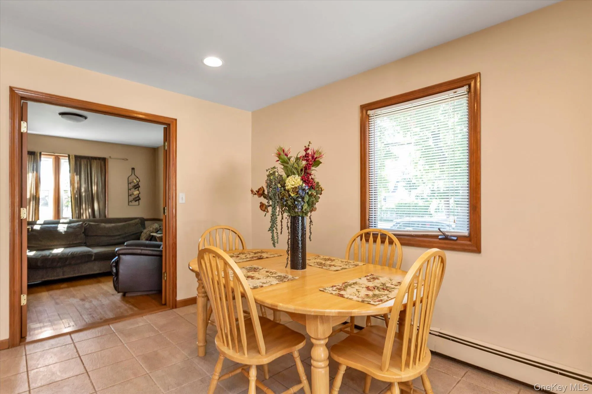 Dining area featuring tile flooring, a window with wood trim, and recessed lighting Dining area featuring tile flooring, a window with wood trim, and recessed lighting