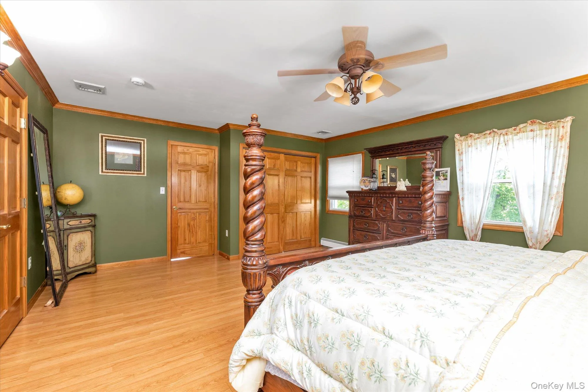 Bright room featuring wood-finish flooring, two natural wood doors, wood trim, and a ceiling fan with integrated lighting Bright room featuring wood-finish flooring, two natural wood doors, wood trim, and a ceiling fan with integrated lighting
