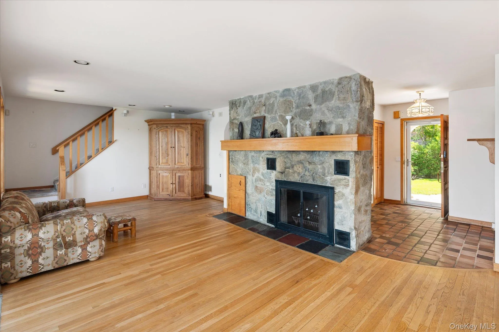 The great room flows seamlessly from the stone fireplace to the lake beyond The great room flows seamlessly from the stone fireplace to the lake beyond