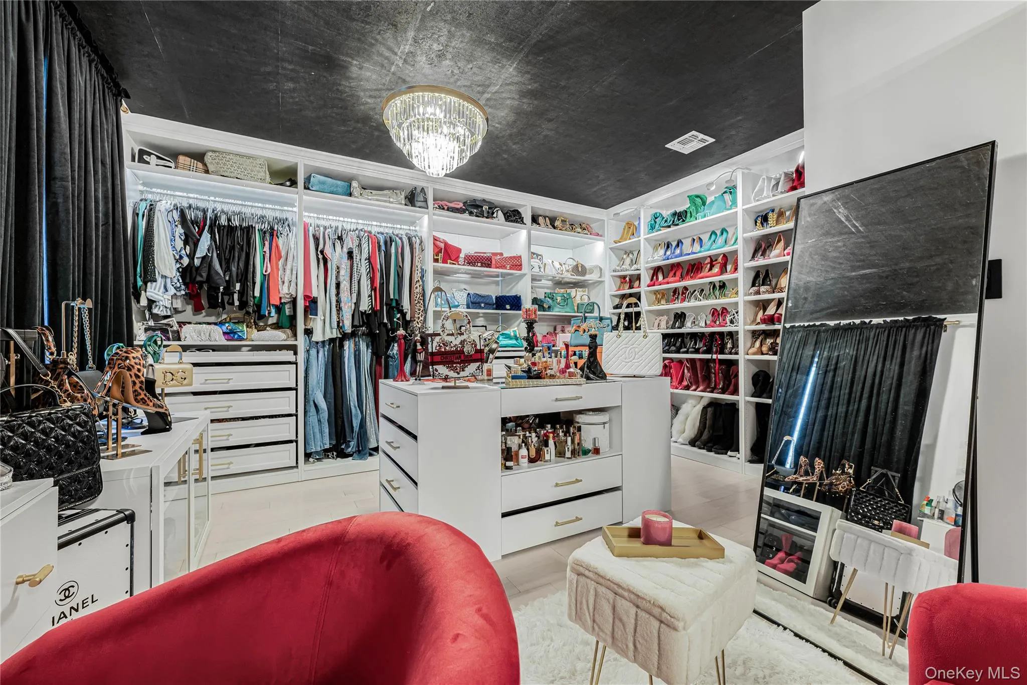Walk in closet featuring a chandelier Walk in closet featuring a chandelier