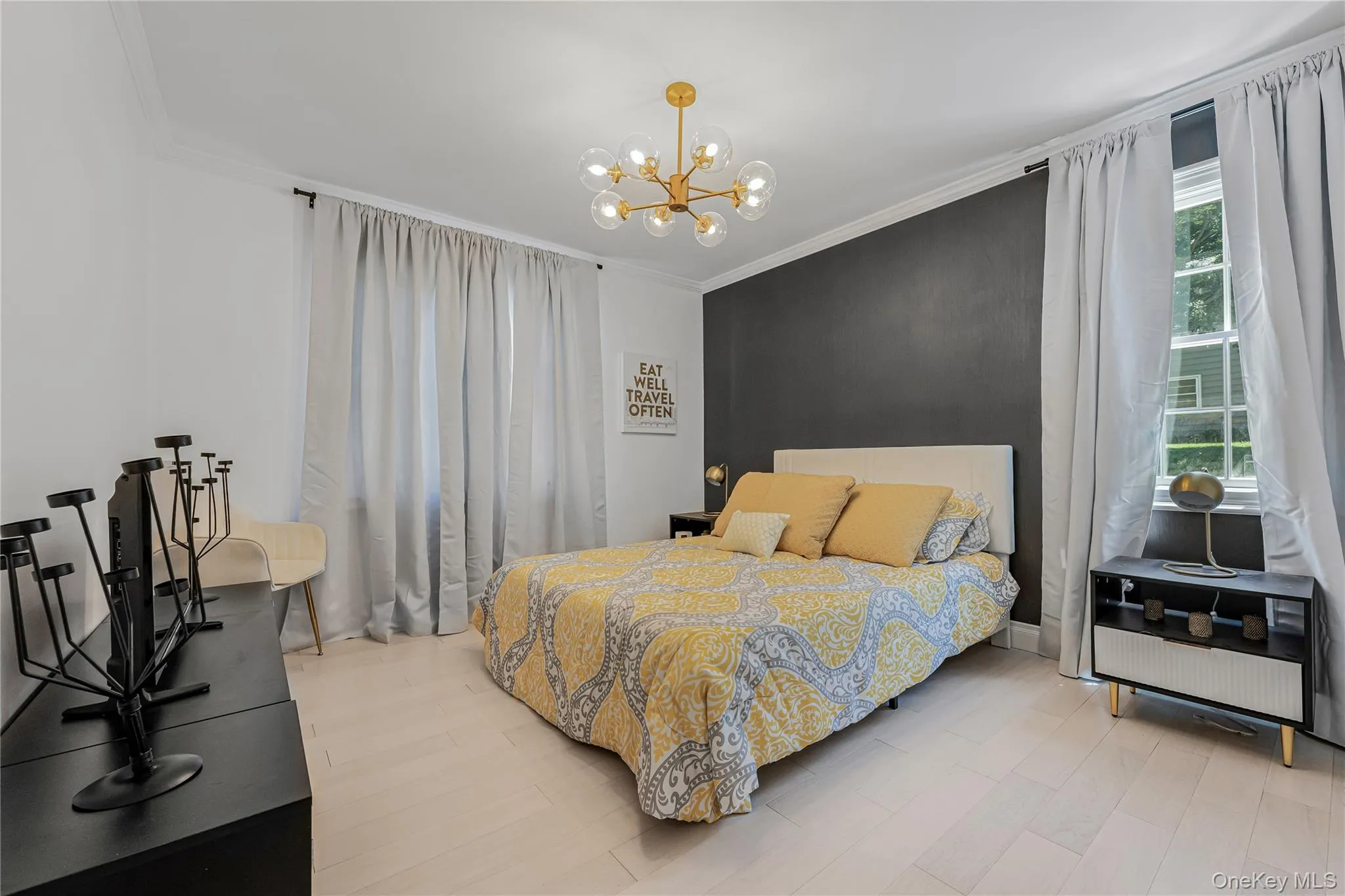 Bedroom featuring crown molding, a chandelier, and wood finished floors Bedroom featuring crown molding, a chandelier, and wood finished floors