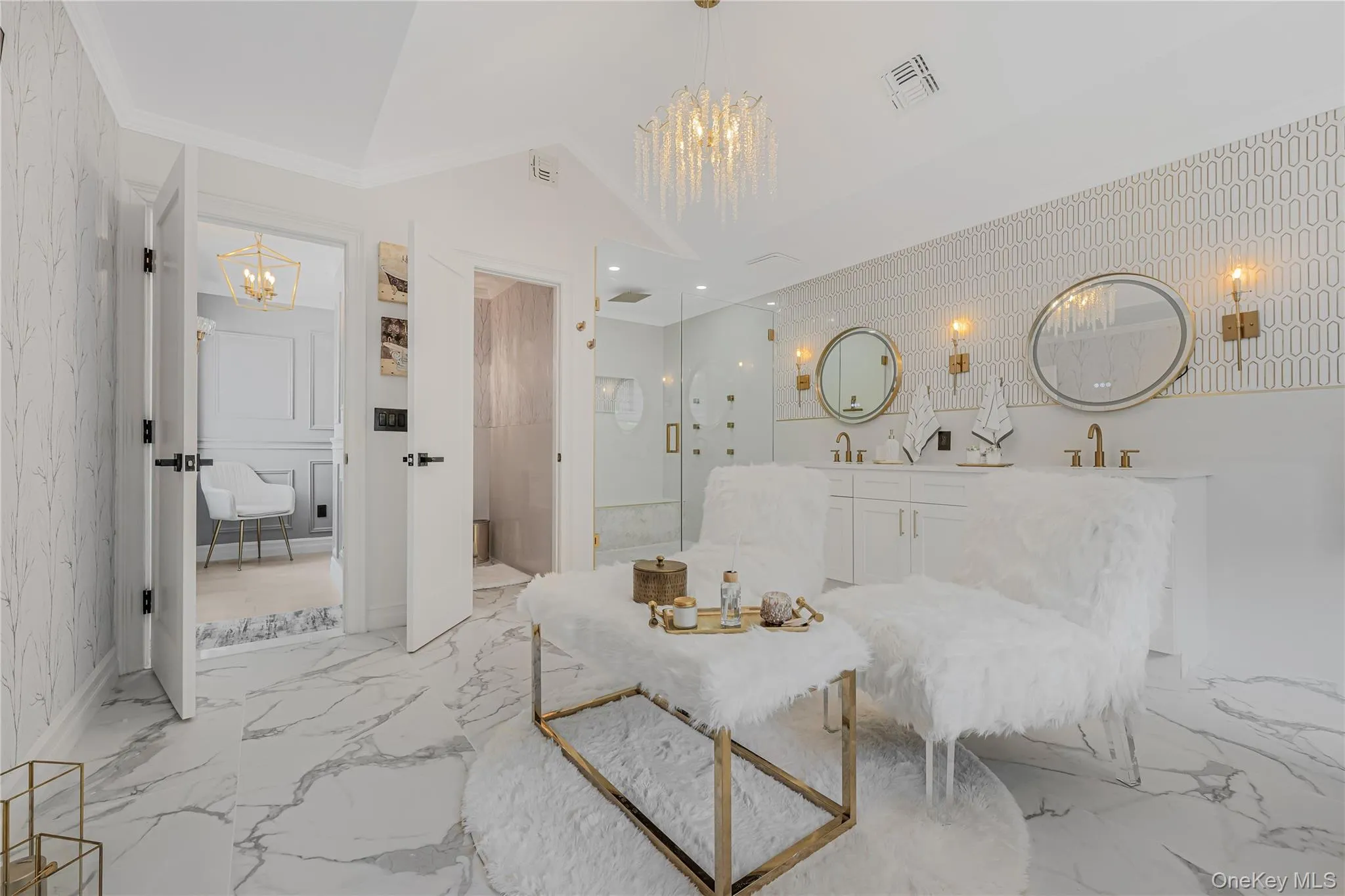 Living area featuring a chandelier, light marble finish flooring, and ornamental molding Living area featuring a chandelier, light marble finish flooring, and ornamental molding