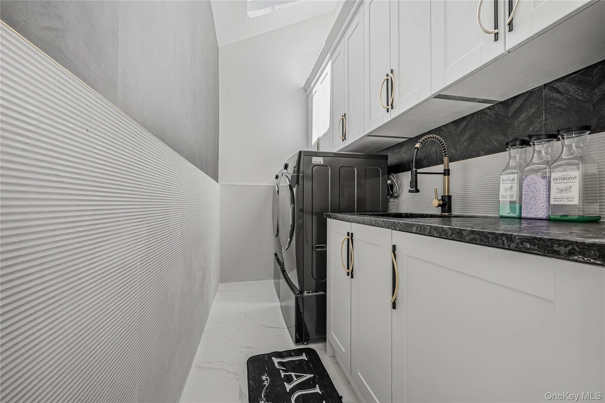 Laundry room with separate washer and dryer, light marble finish floors, and cabinet space Laundry room with separate washer and dryer, light marble finish floors, and cabinet space
