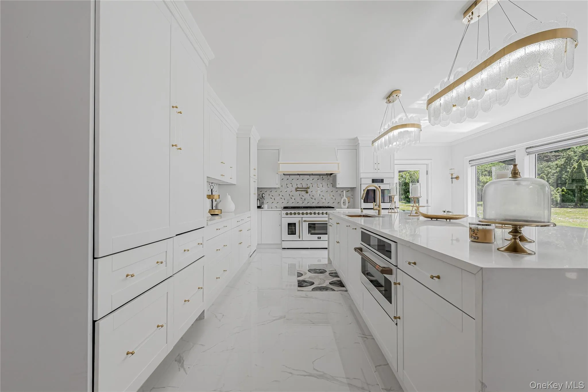 Kitchen with light marble finish floors, white appliances, white cabinets, tasteful backsplash, and light countertops Kitchen with light marble finish floors, white appliances, white cabinets, tasteful backsplash, and light countertops