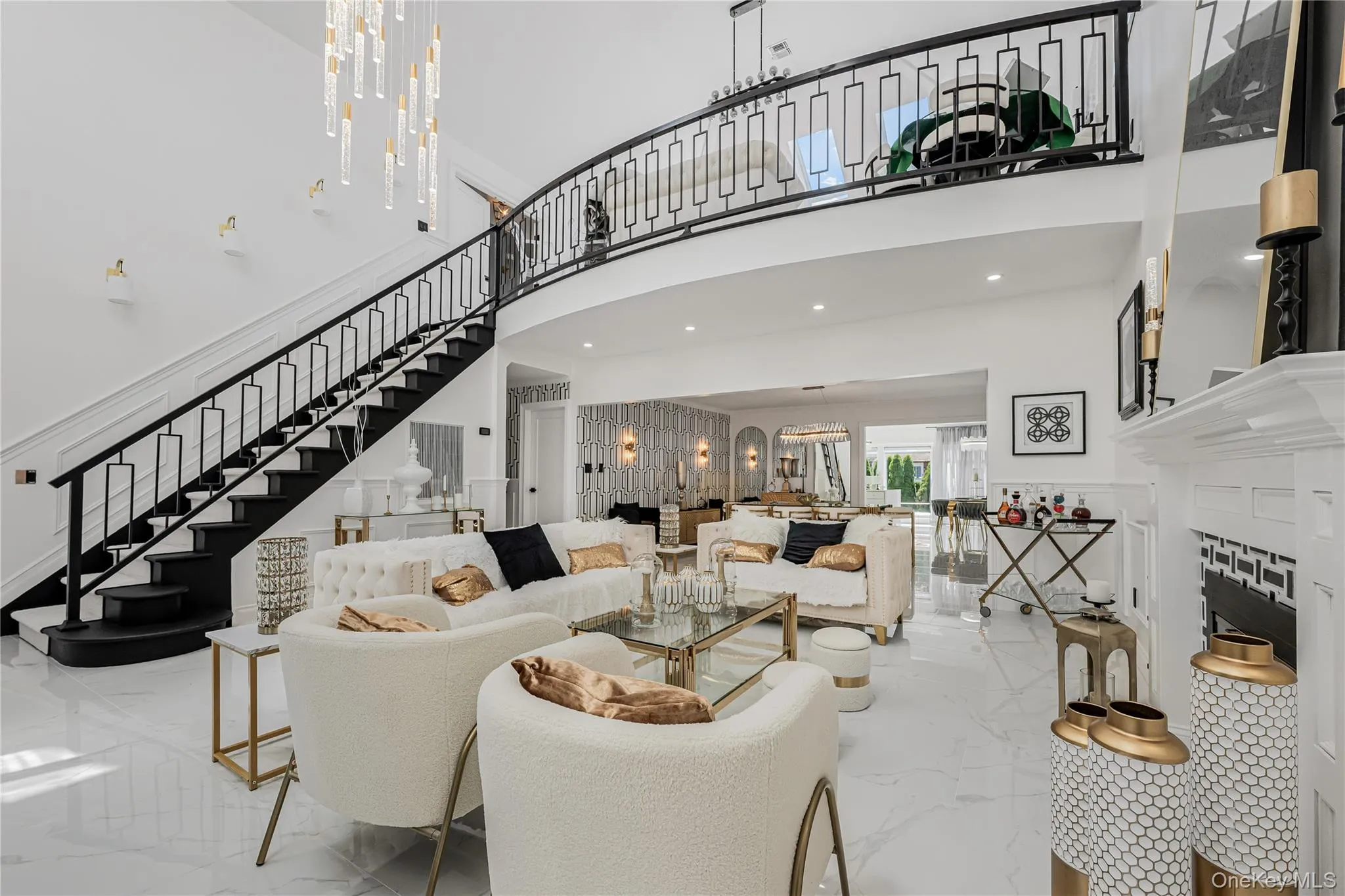 Living room with marble tiled flooring, stairs, a towering ceiling, and a chandelier Living room with marble tiled flooring, stairs, a towering ceiling, and a chandelier