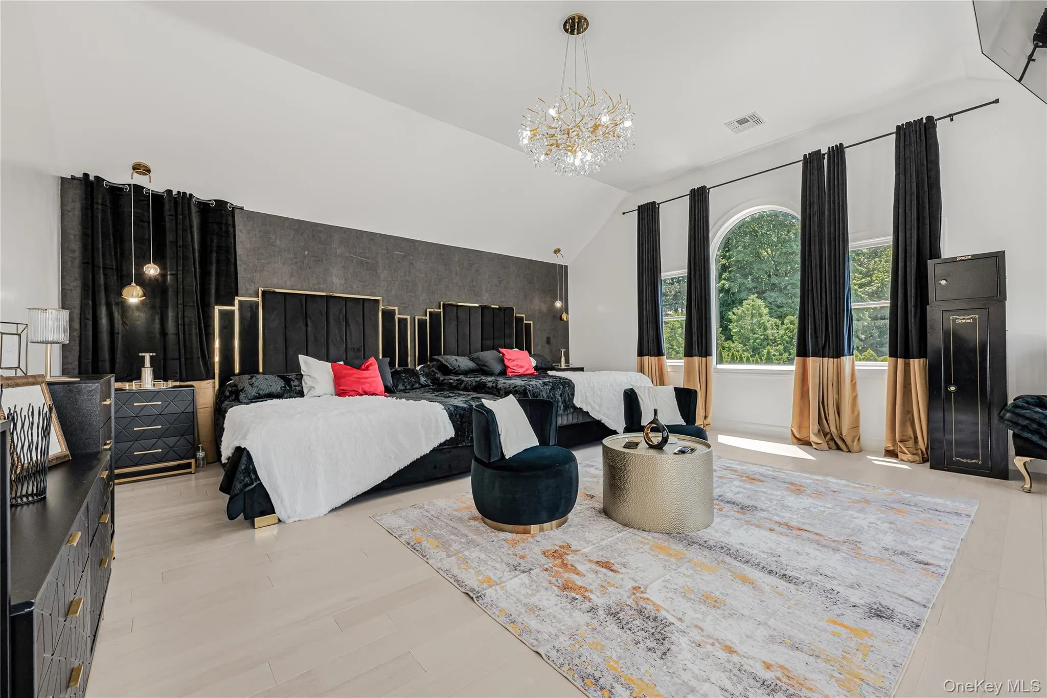 Bedroom featuring an accent wall, a chandelier, and lofted ceiling Bedroom featuring an accent wall, a chandelier, and lofted ceiling
