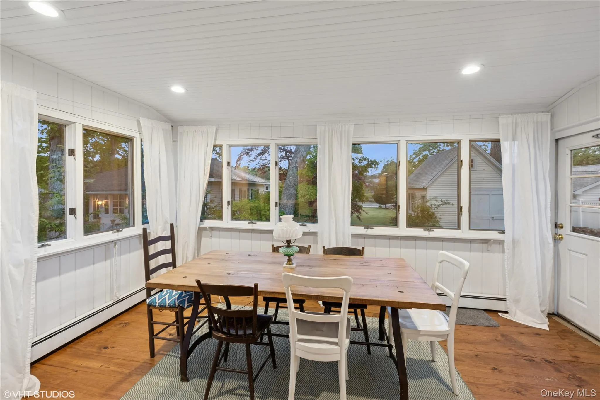 Sunroom featuring baseboard heating, hardwood / wood-style flooring, a deck, and recessed lighting Sunroom featuring baseboard heating, hardwood / wood-style flooring, a deck, and recessed lighting