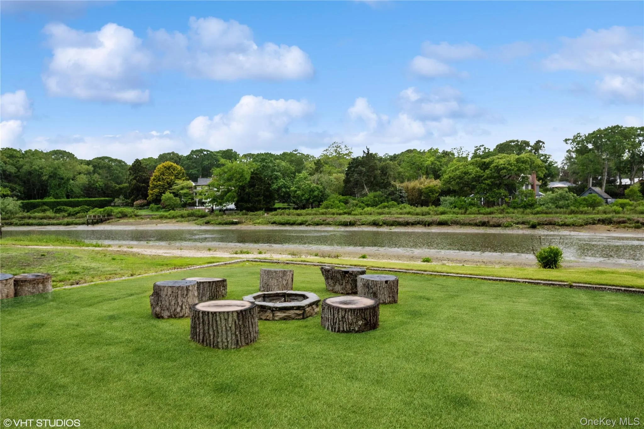 View of grassy yard with a fire pit and a water view View of grassy yard with a fire pit and a water view