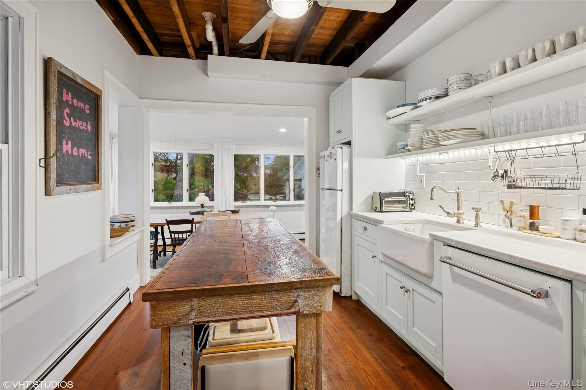 Kitchen featuring white appliances, a baseboard heating unit, open shelves, wooden ceiling with exposed beams, and a sink Kitchen featuring white appliances, a baseboard heating unit, open shelves, wooden ceiling with exposed beams, and a sink